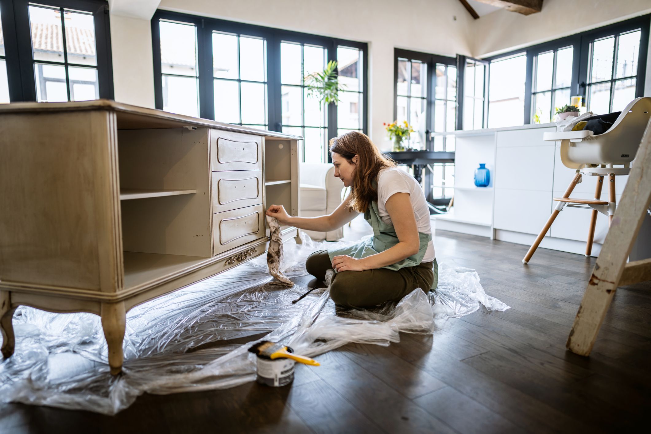 Photo of happy young woman coloring a showcase at her living room.