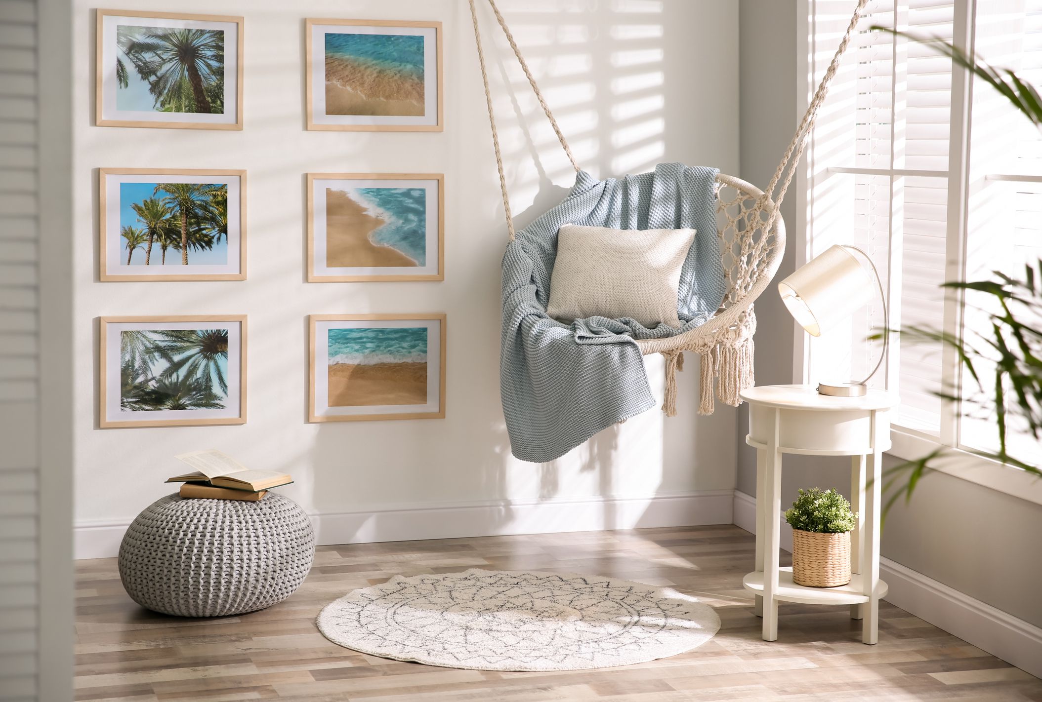 Stylish room interior with artworks and hanging chair