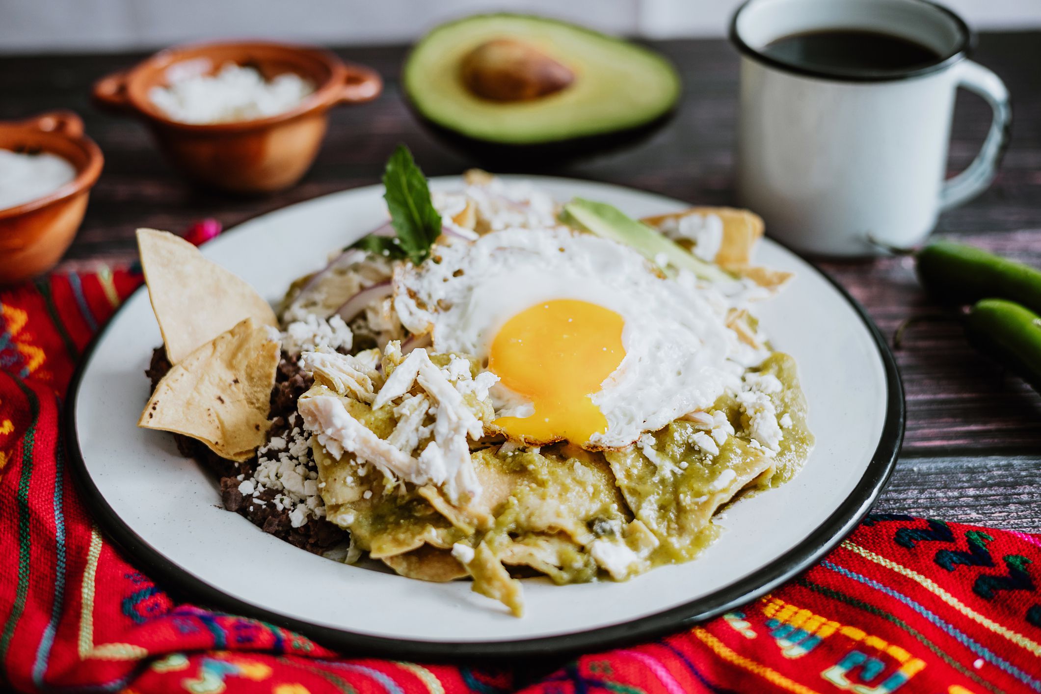 mexican chilaquiles with fried egg, chicken and spicy green sauce traditional breakfast in Mexico