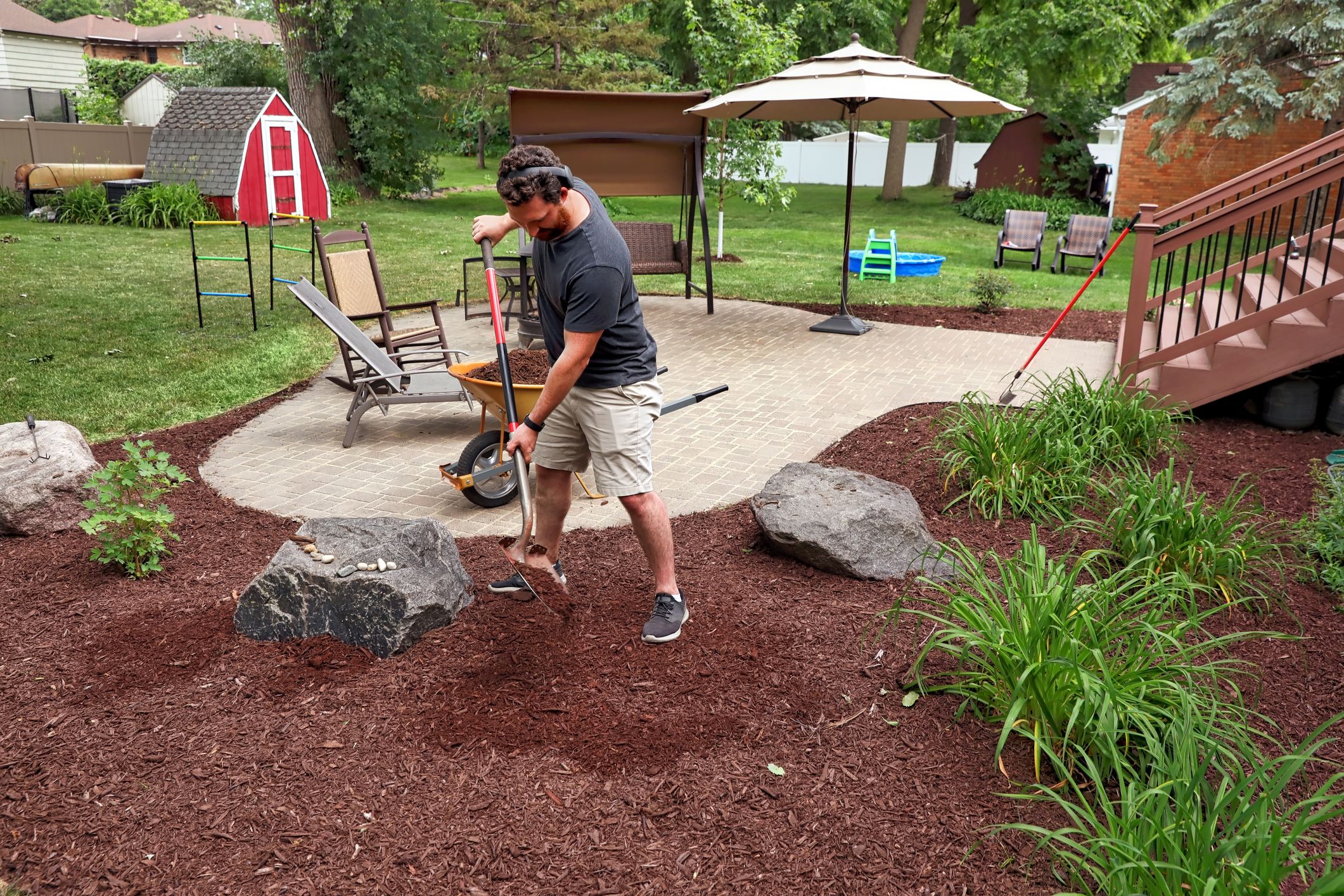Man mulching yard in suburban house