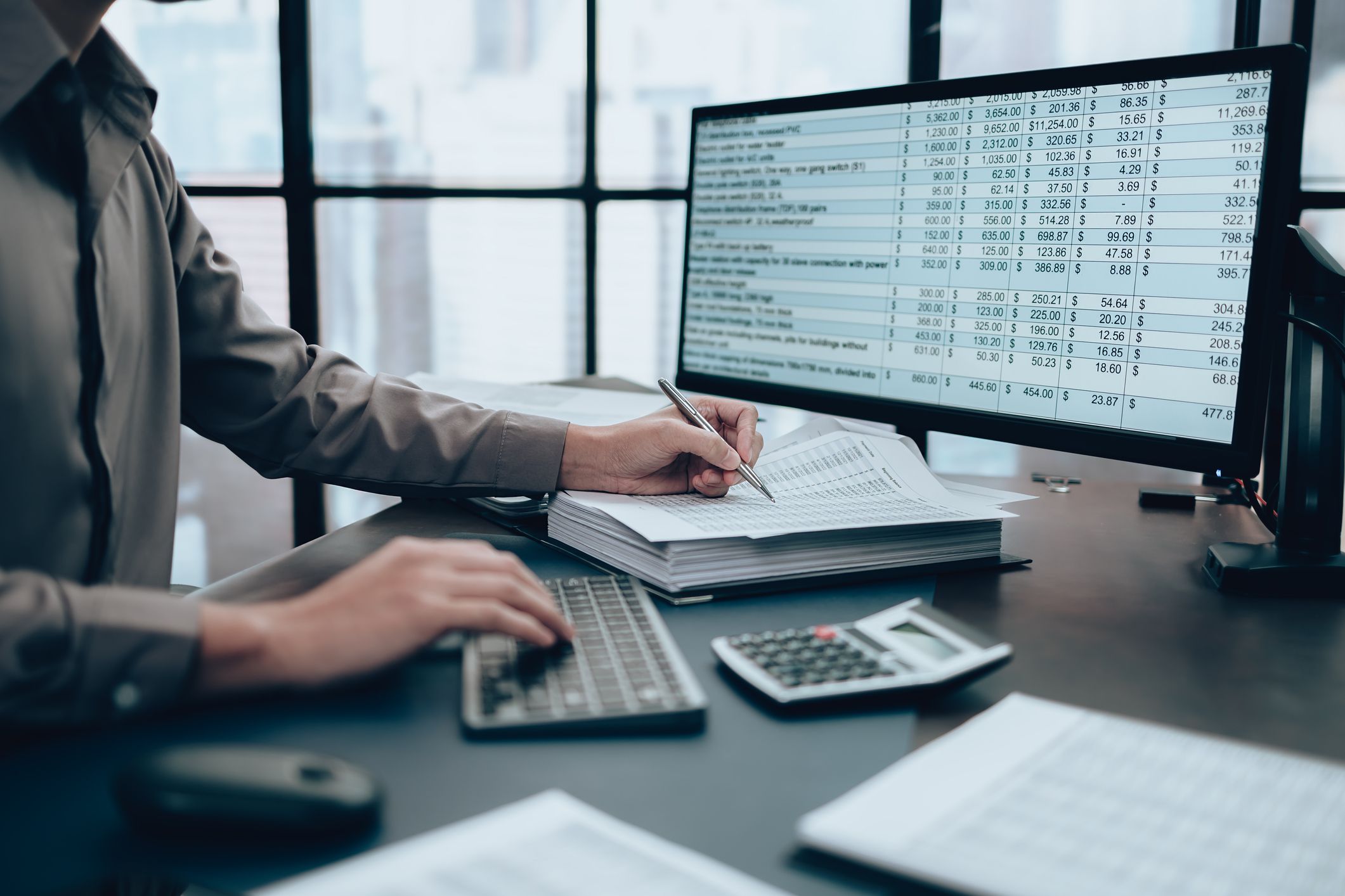 Investors working on desk office and using a pan and pointing to check tracking cost, balance, profit and currency. Accounting and Financial concept.