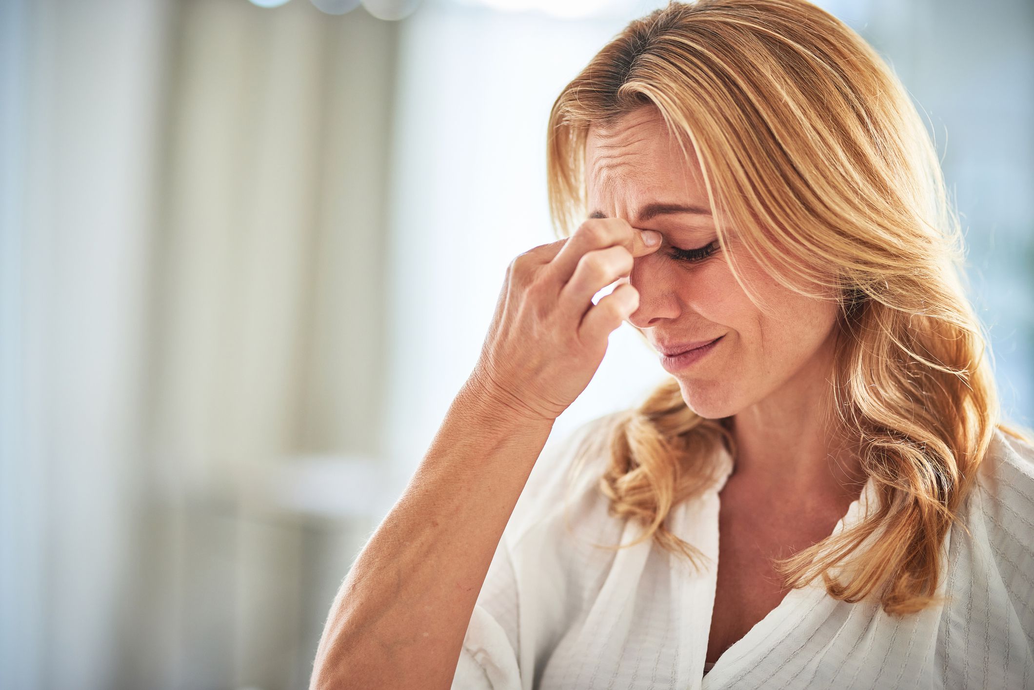 Woman with stress headache, crisis and mental health problem, sad with depression and anxiety. Depressed female at home, confused or tired with brain fog, person with worried face and issues in life