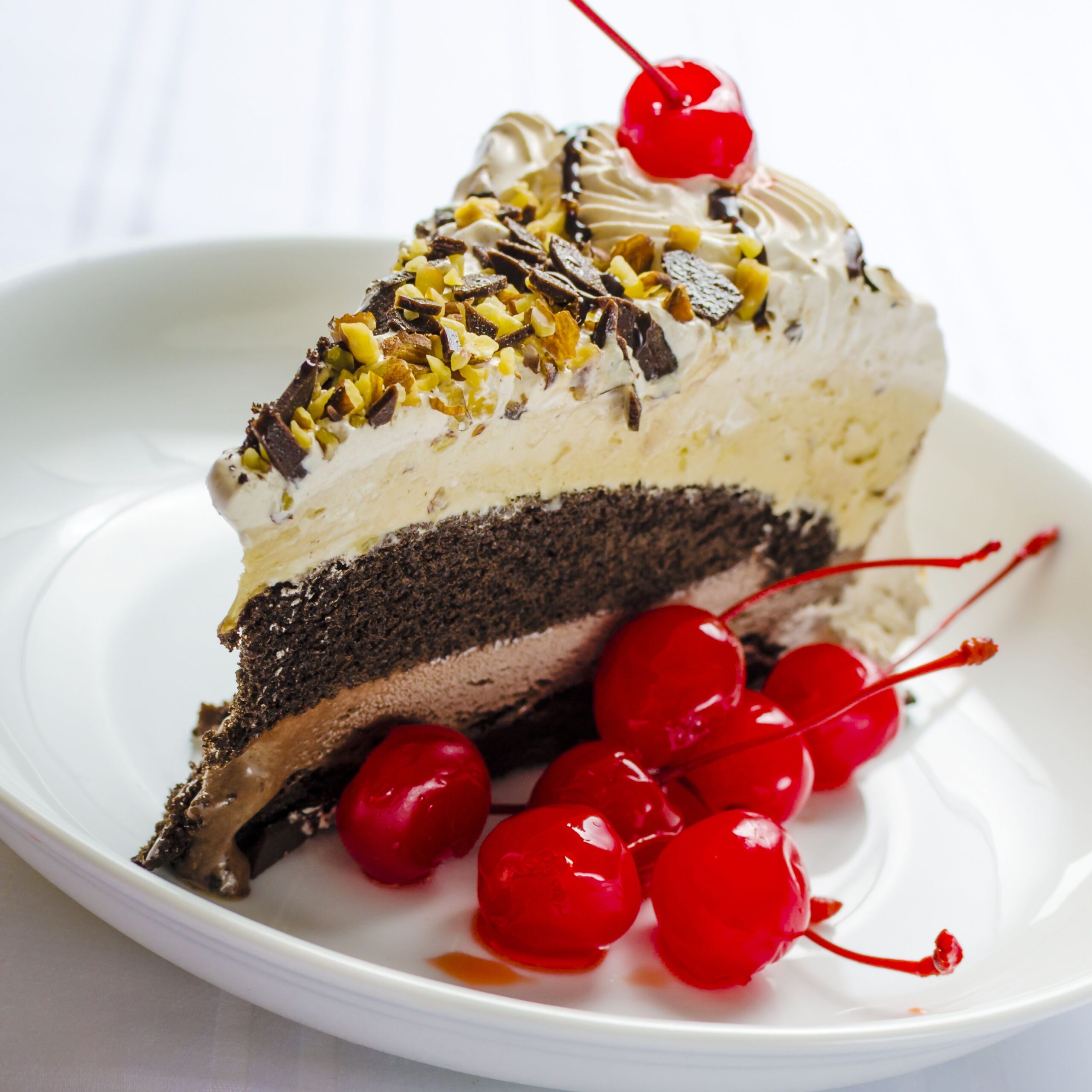 Piece of chocolate ice cream cake garnished with a cherry