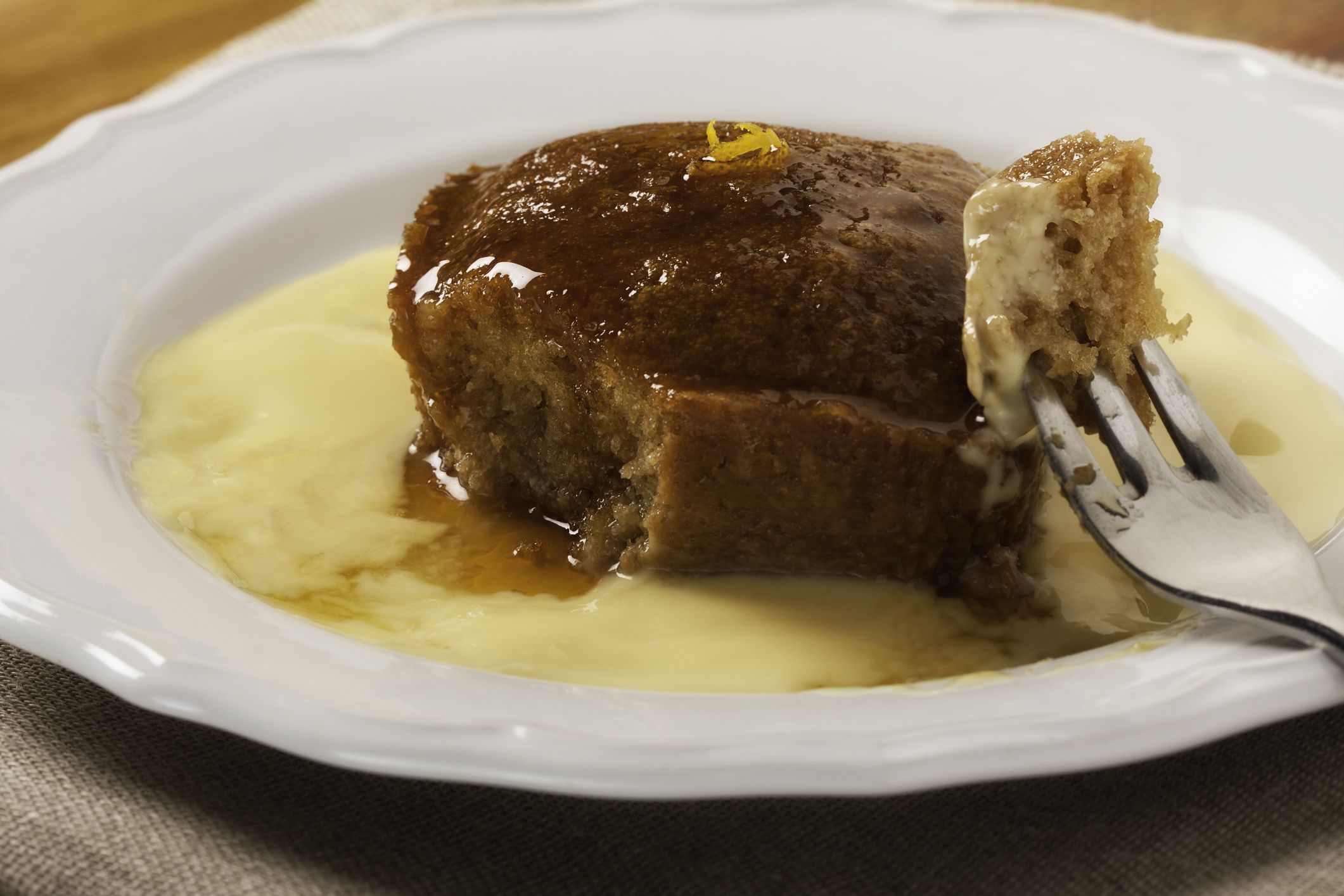 Malva pudding. Traditional South African dessert. Spongy cake with a caramelized butter sauce. Served with custard