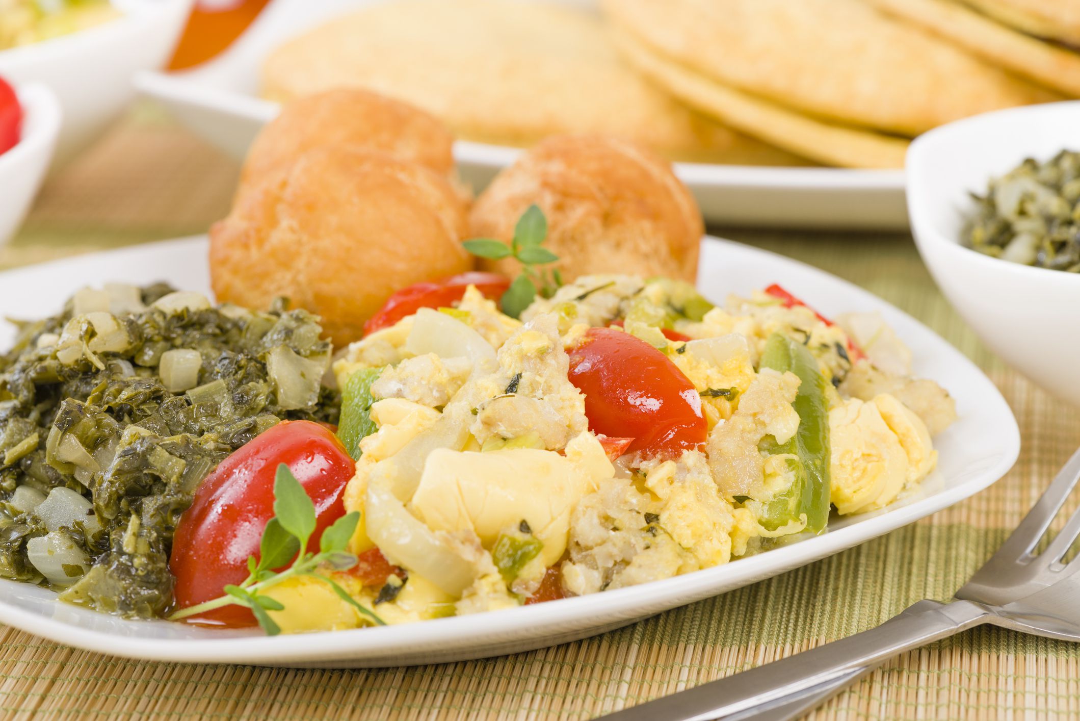 Ackee & Saltfish - Traditional Jamaican dish made of salt cod and ackee fruit. Served with callaloo and johnny cakes.