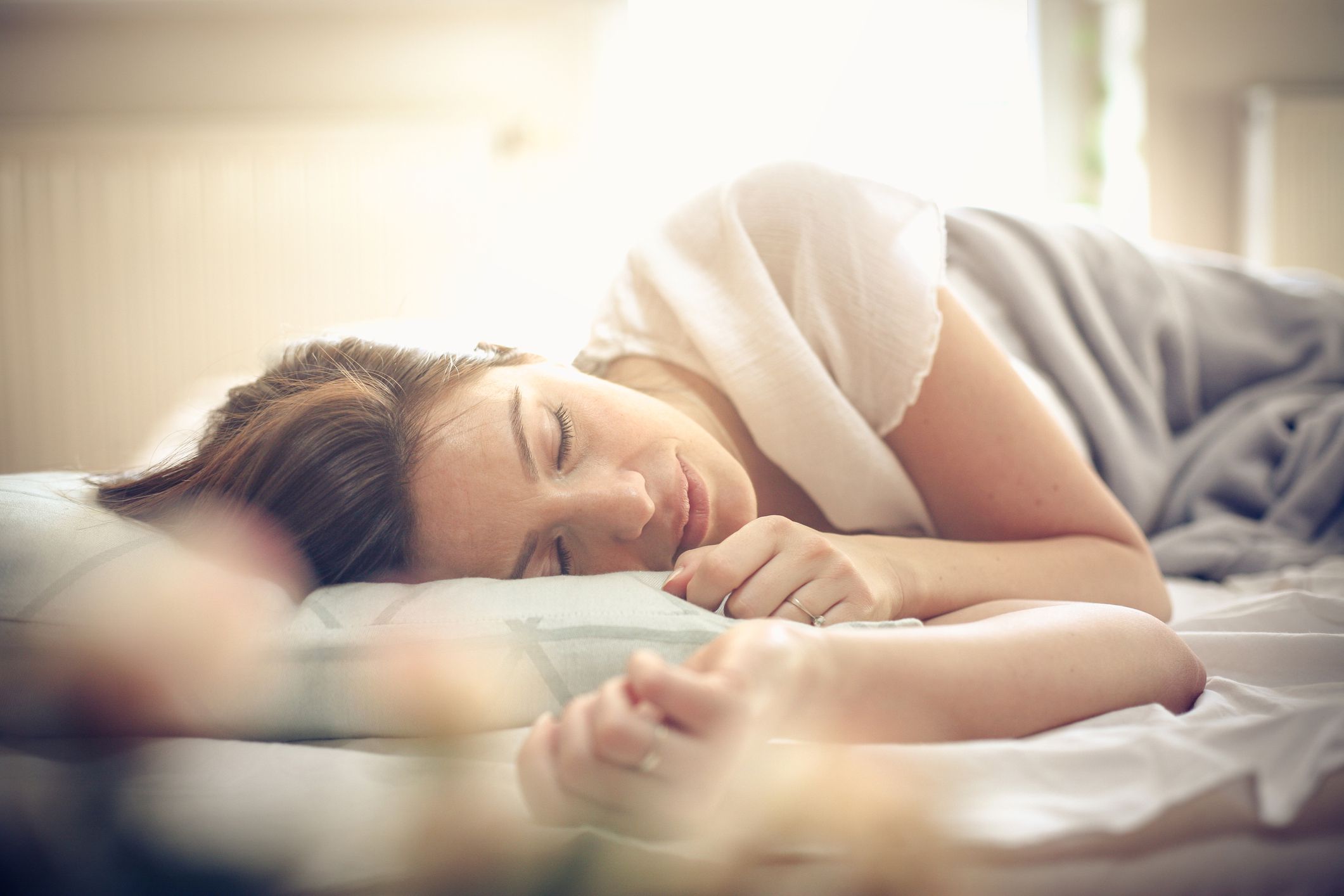 Young woman sleeping in bed. Space for copy.