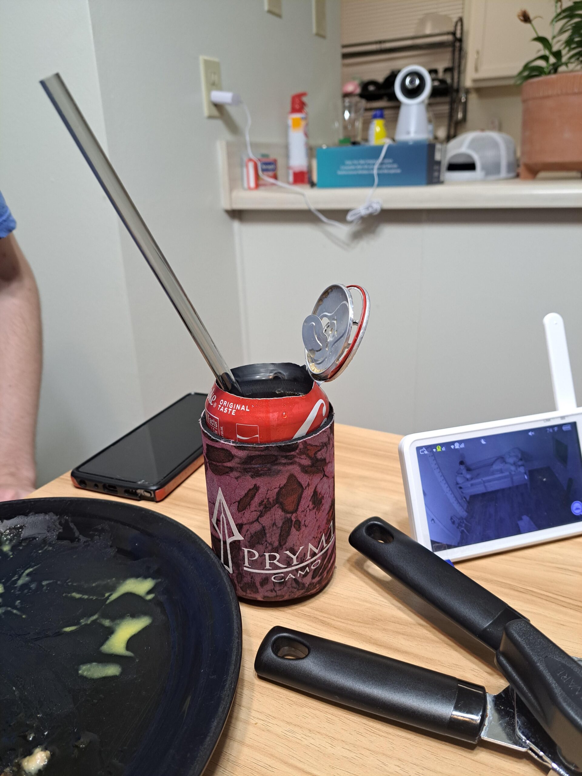 Soda can ripped open and a straw inserted