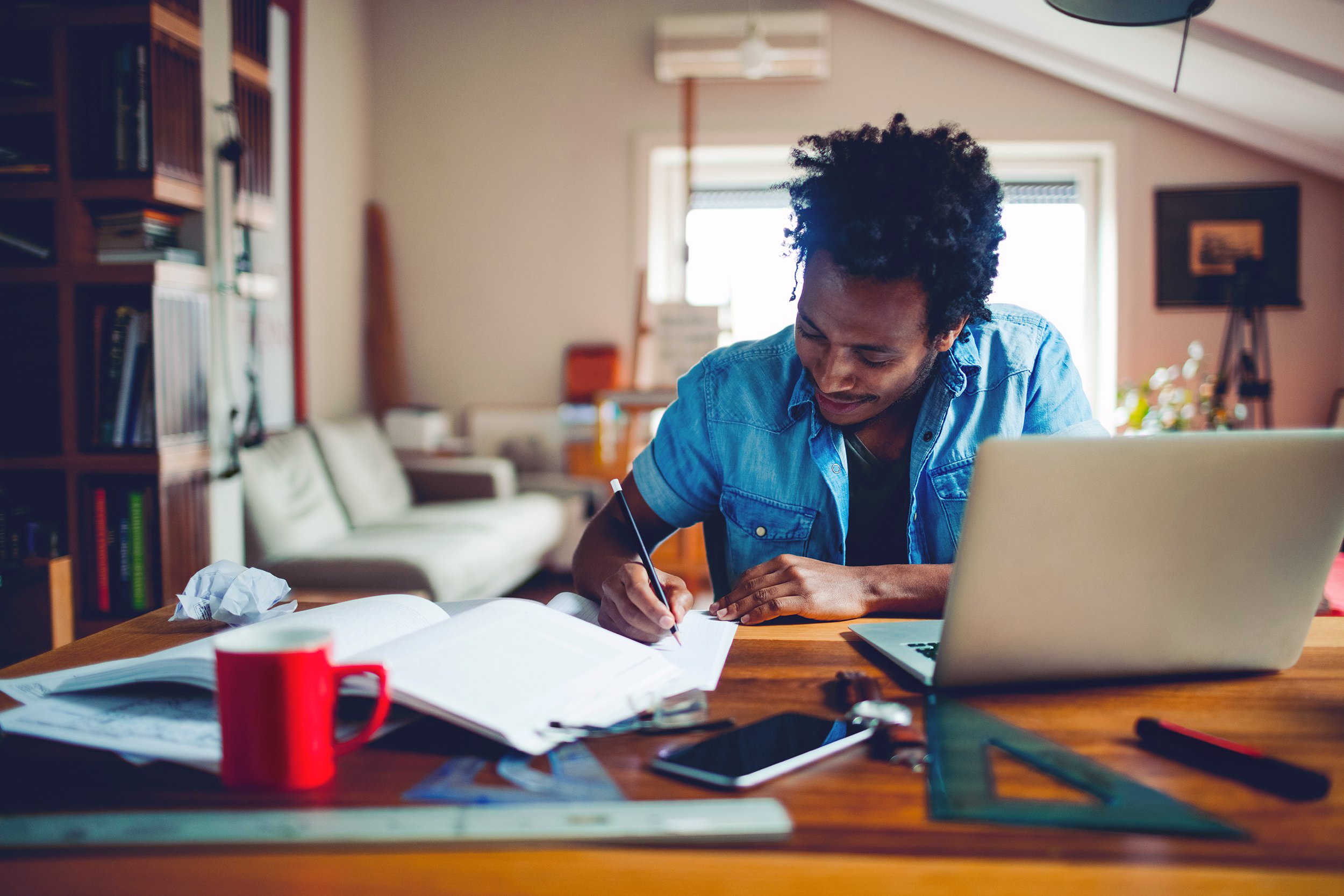 young African American adult, studying on desk