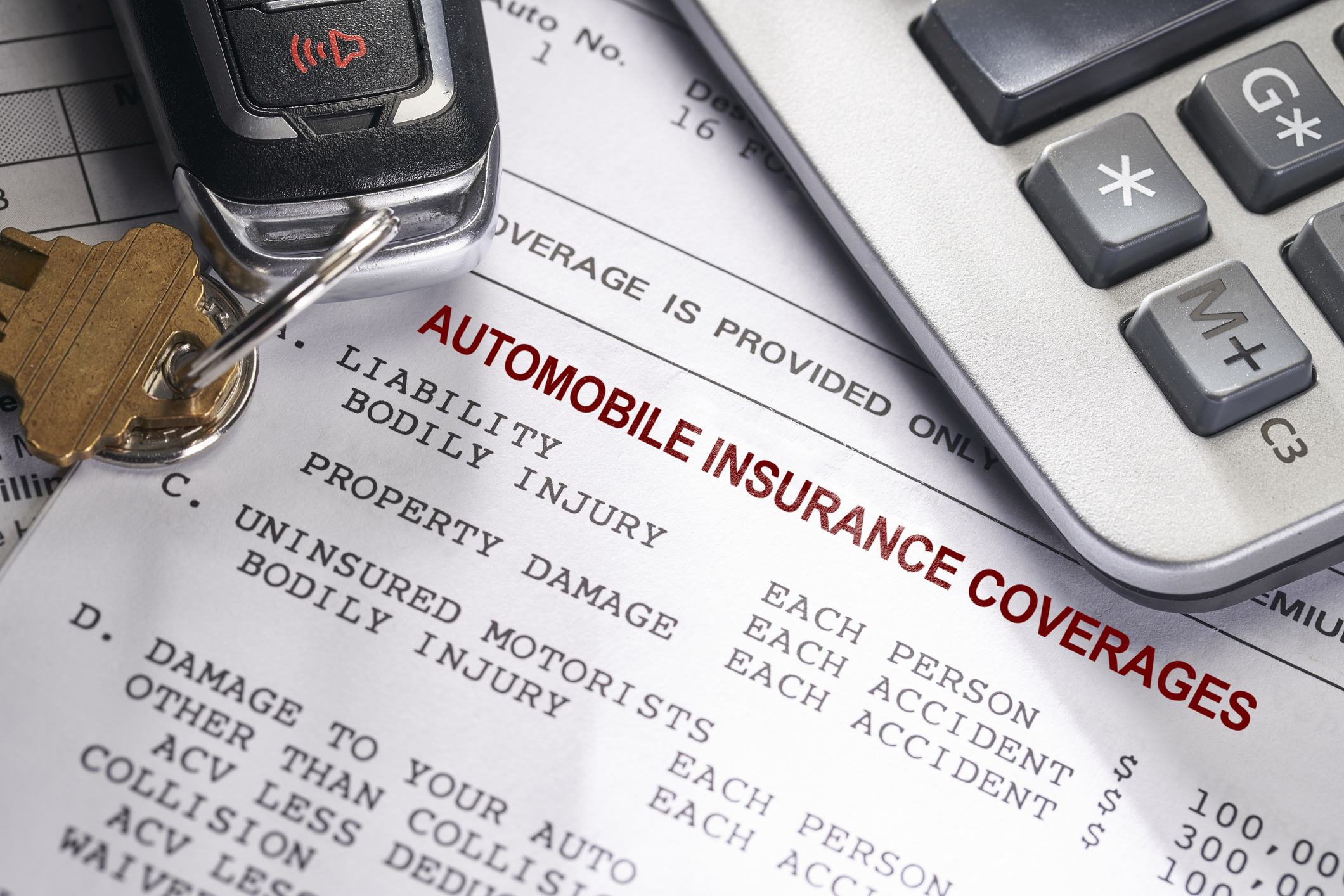 Car Keys and Calculator on Paper Car Insurance Bill