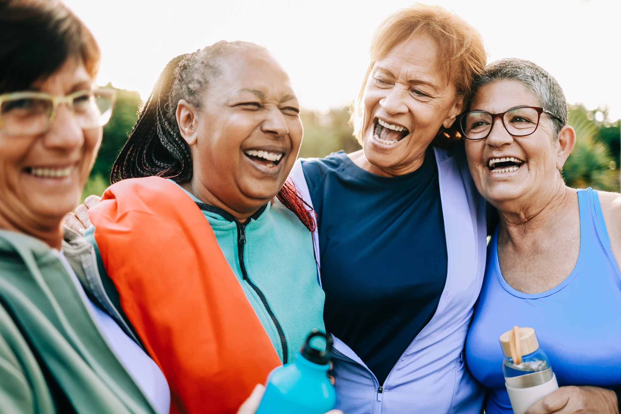 Group of Four Senior Woman Friends Hugging Each Other After an Outside Exercise Session
