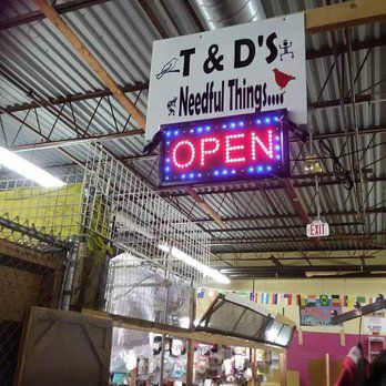 a sign that says T&D Needful Things hanging from a store ceiling