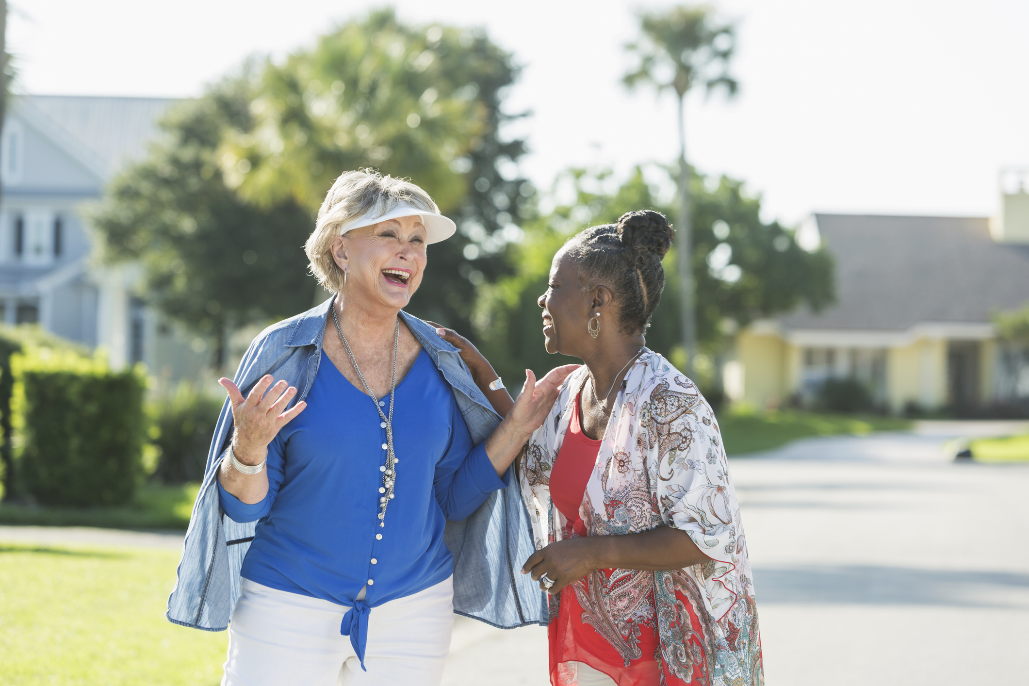 Two Happy Senior Women Taking a Walk in a Suburban Neighborhood, Talking