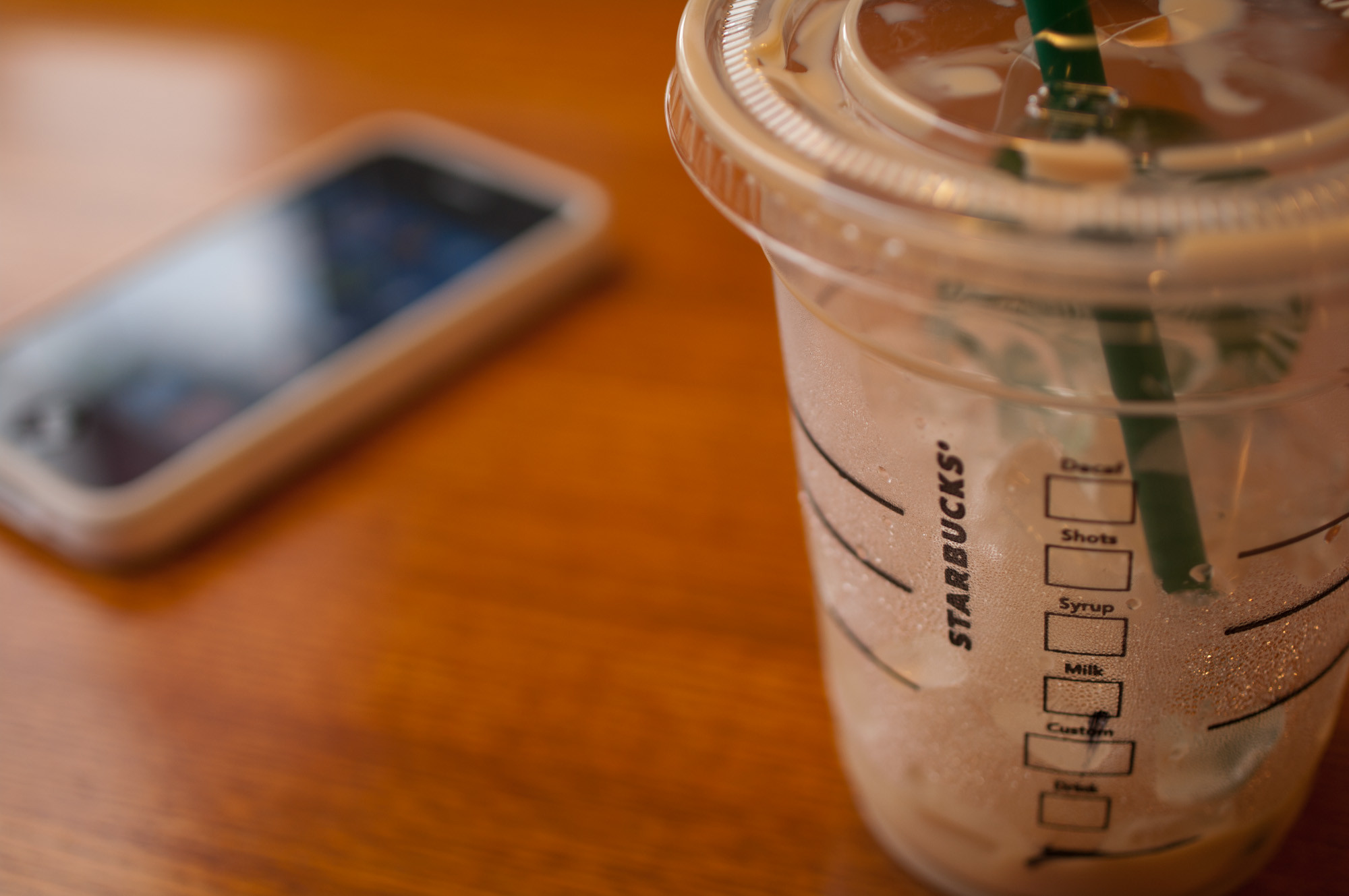 Closeup of a Finished Iced Grande Starbucks Latte on Table, Selective Focus