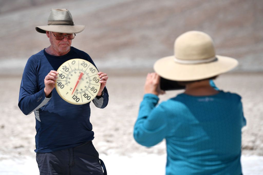 George Harris (L) is photographed by Margaret Owen as he displays a thermometer at Badwater Basin on July 11, 2021 in Death Valley National Park, California. An excessive heat warning was issued for much of the Southwest United States through Monday. Clim