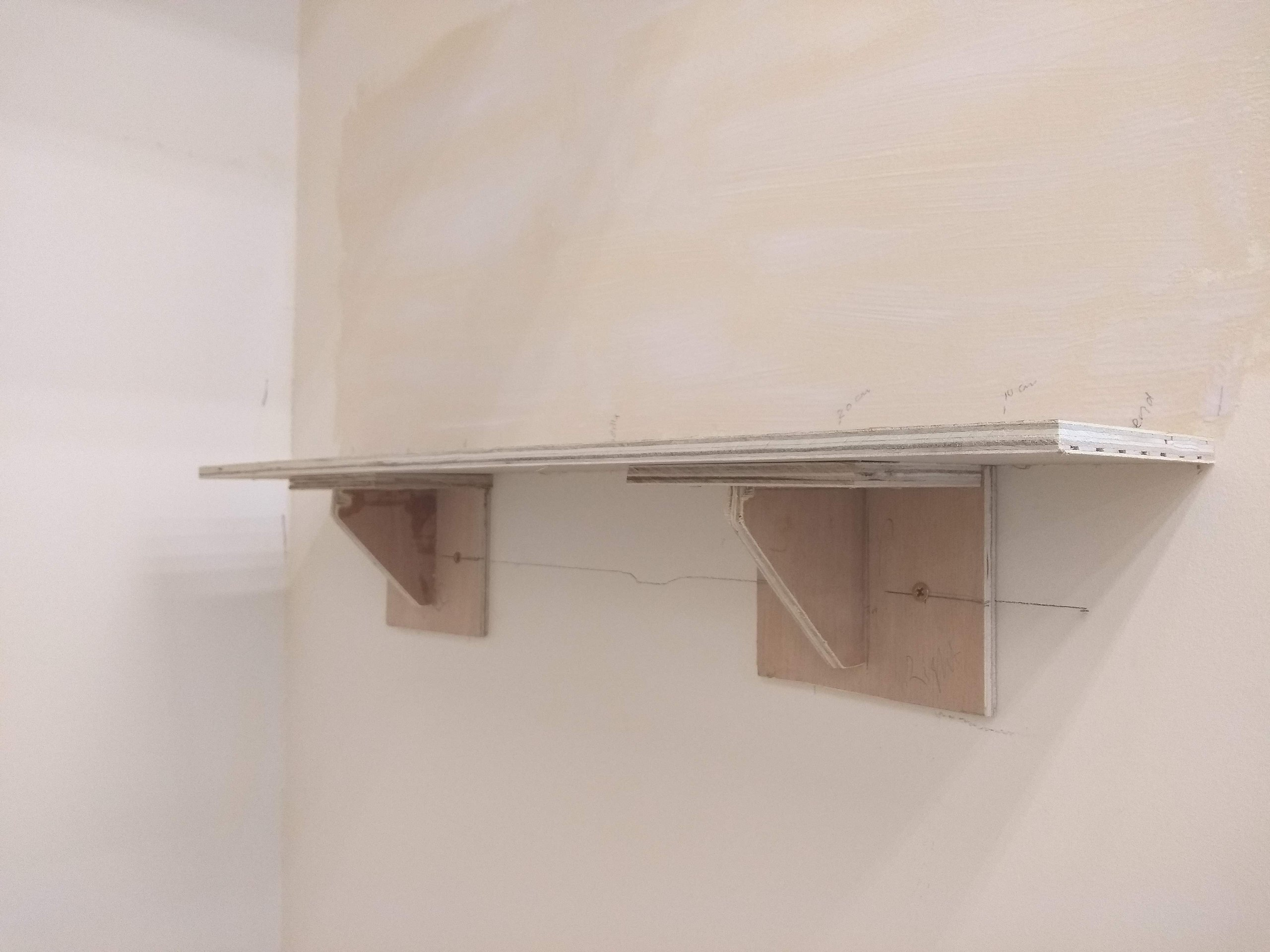 Plain Wooden Shelf Nailed to the White Wall