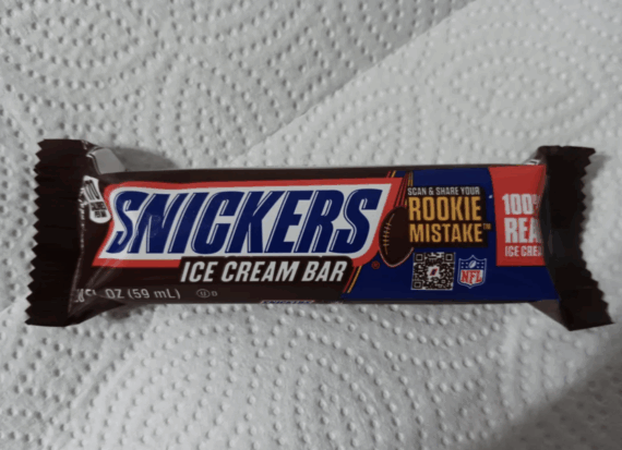 A Snickers ice cream bar wrapper with a “Rookie Mistake” promotion, a football graphic, and an NFL logo.