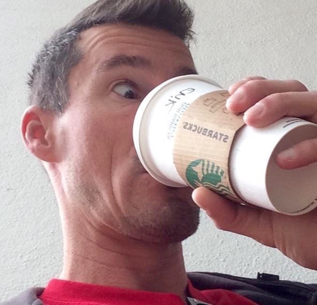 Surprised Man Drinking a Hot Grande Starbucks Drink