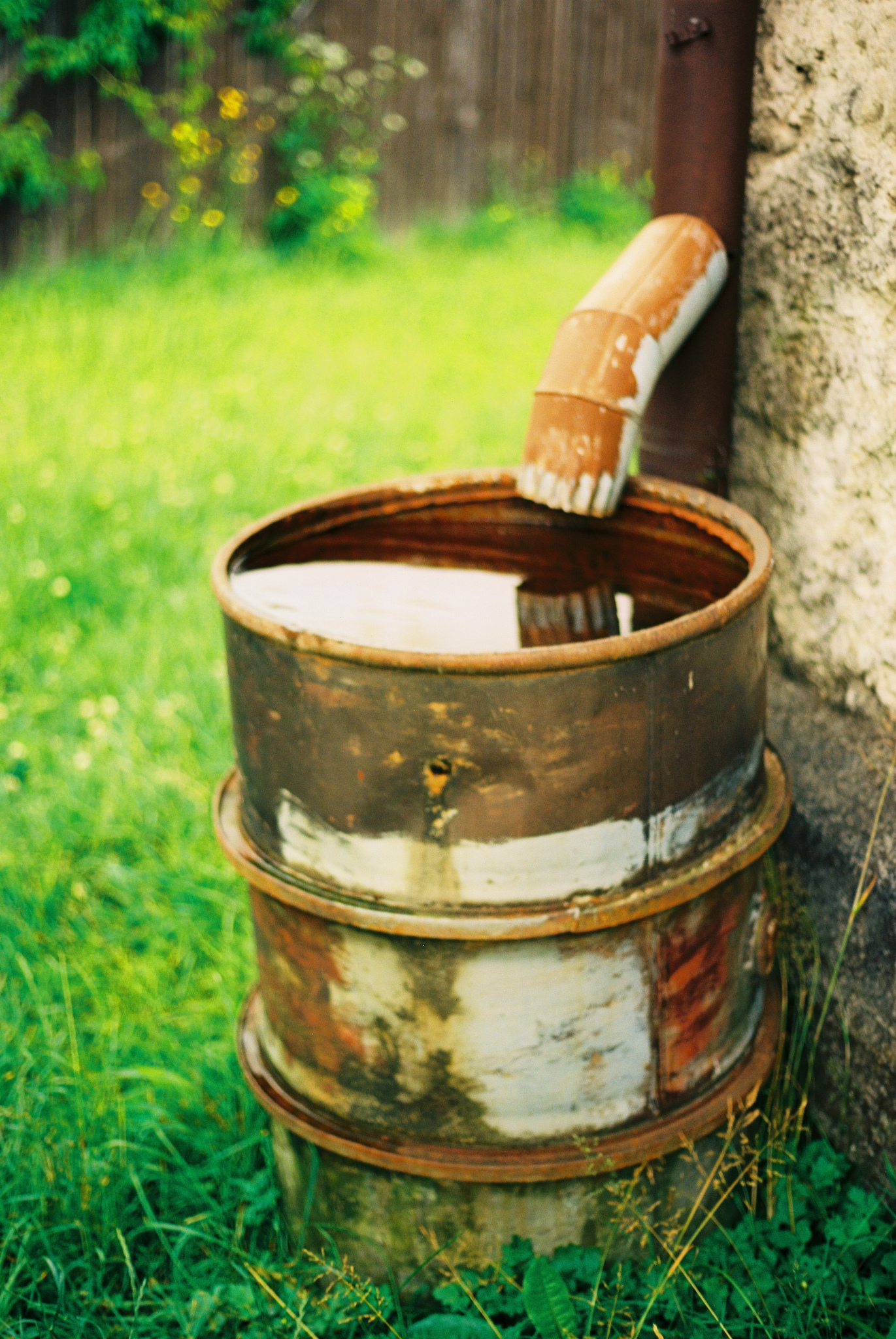 Vintage Rain Barrel Under a Downspout of a Home