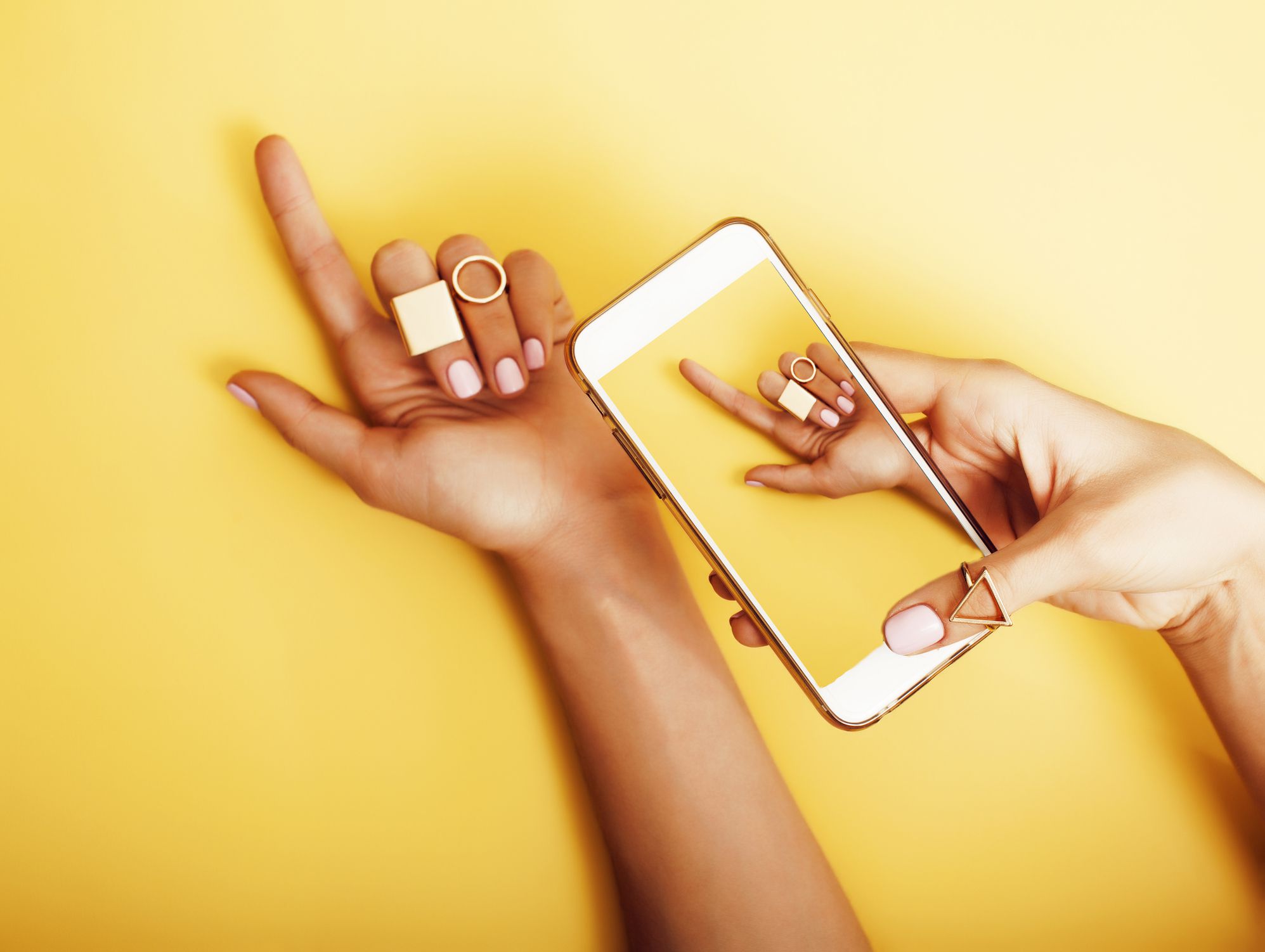 womans hand taking picture of her new manicure with fashion jewellery on her phone, girls stuff concept close up