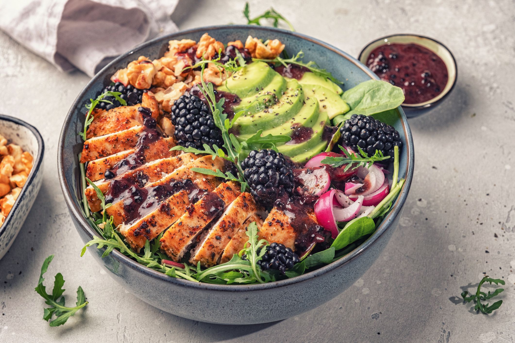 Grilled chicken breast, fillet and fresh vegetable salad of lettuce, arugula, spinach, avocado, onion and walnut with blackberry dressing. Summer salad, healthy eating. Fresh healthy food.