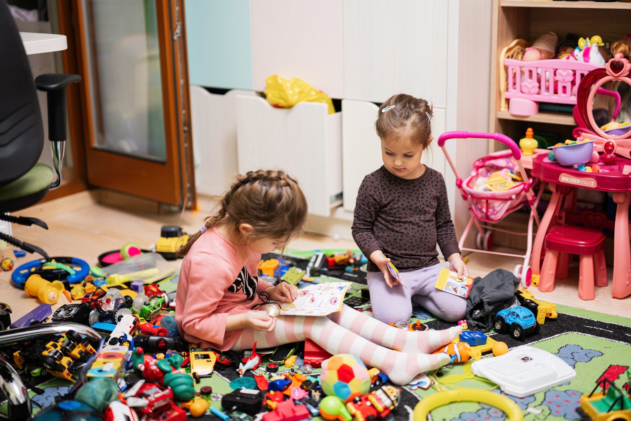 hildren have made a toy mess in the children's room and are playing with toys.