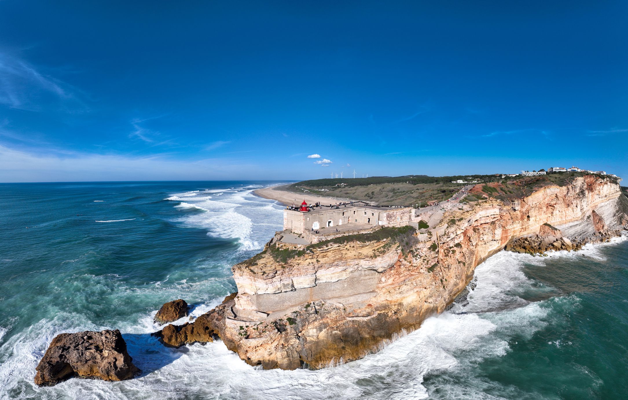 Lighthouse in Nazare, Portugal. Famous place for waves and surfing. Beach and Ocean Waves in Background