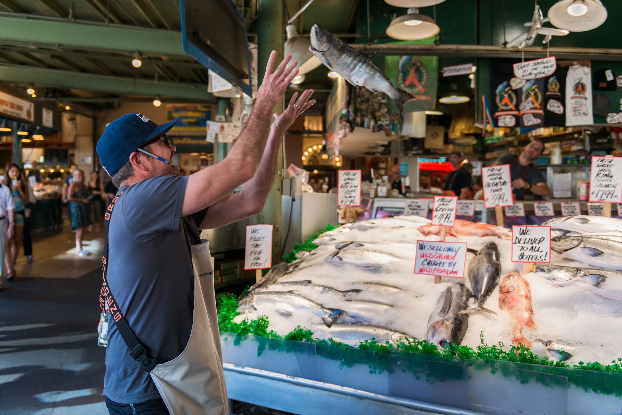 Seattle, USA - August 18, 2015: A fish Monger at Pike Place Market catching a fish for tourists late in the day.