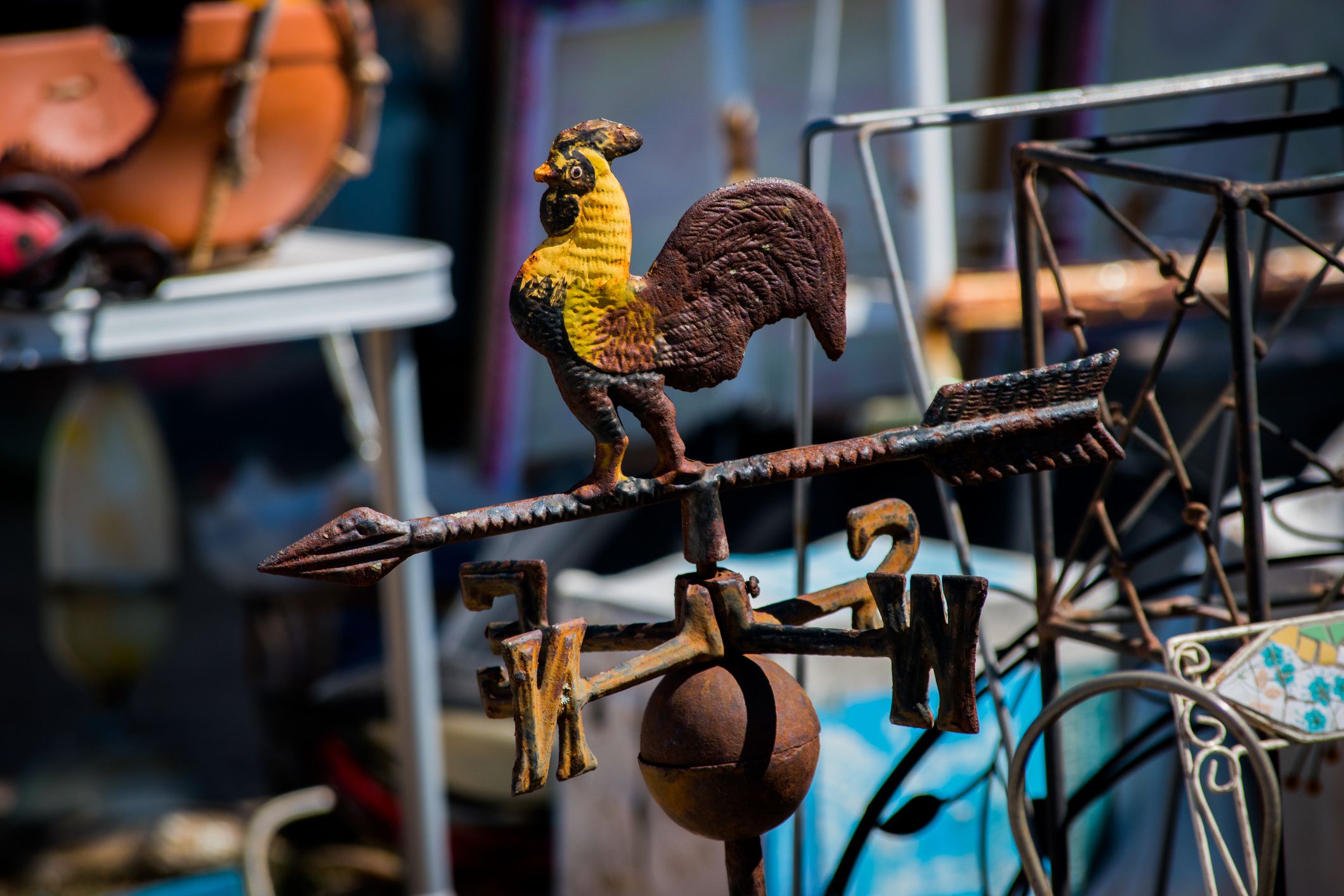 Rusty rooster weather vane for sale at a flea market