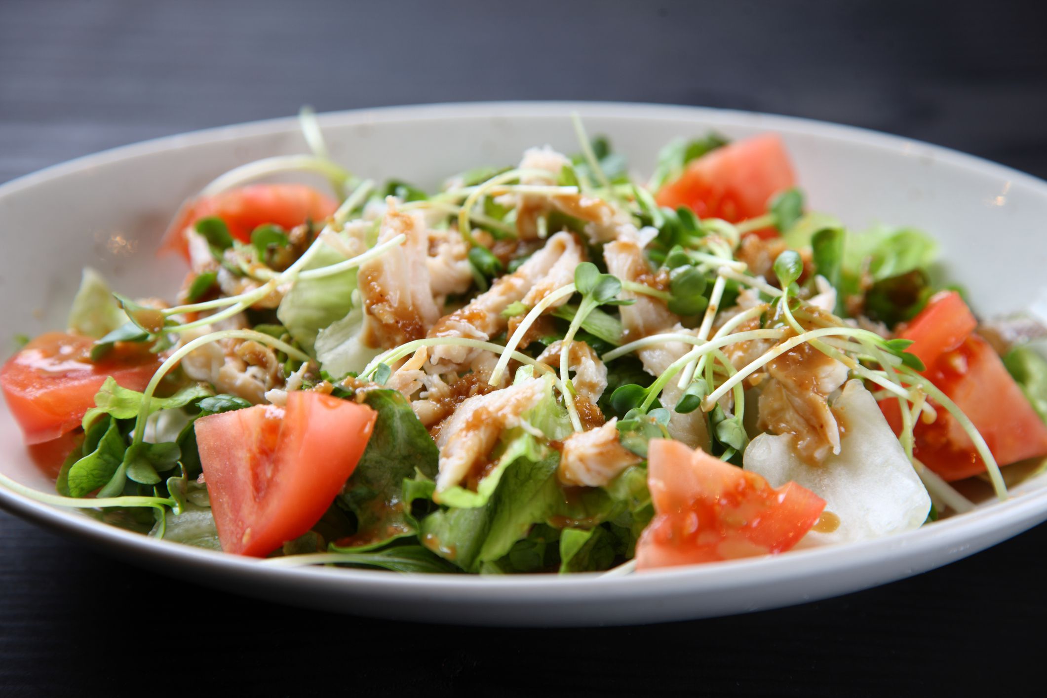 studio shot of tomato with Chicken salad on black background