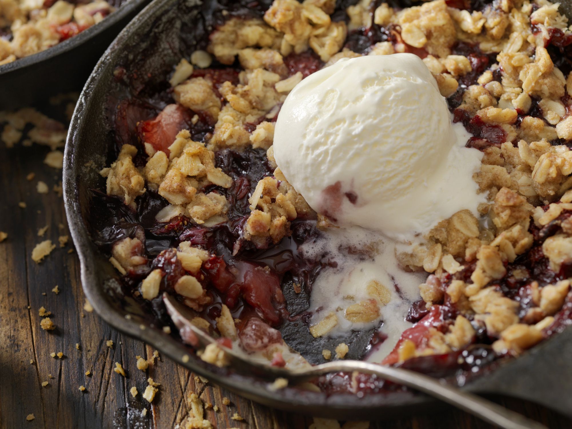 Strawberry and Blueberry Crisp with Vanilla Ice Cream in a Cast Iron Skillet