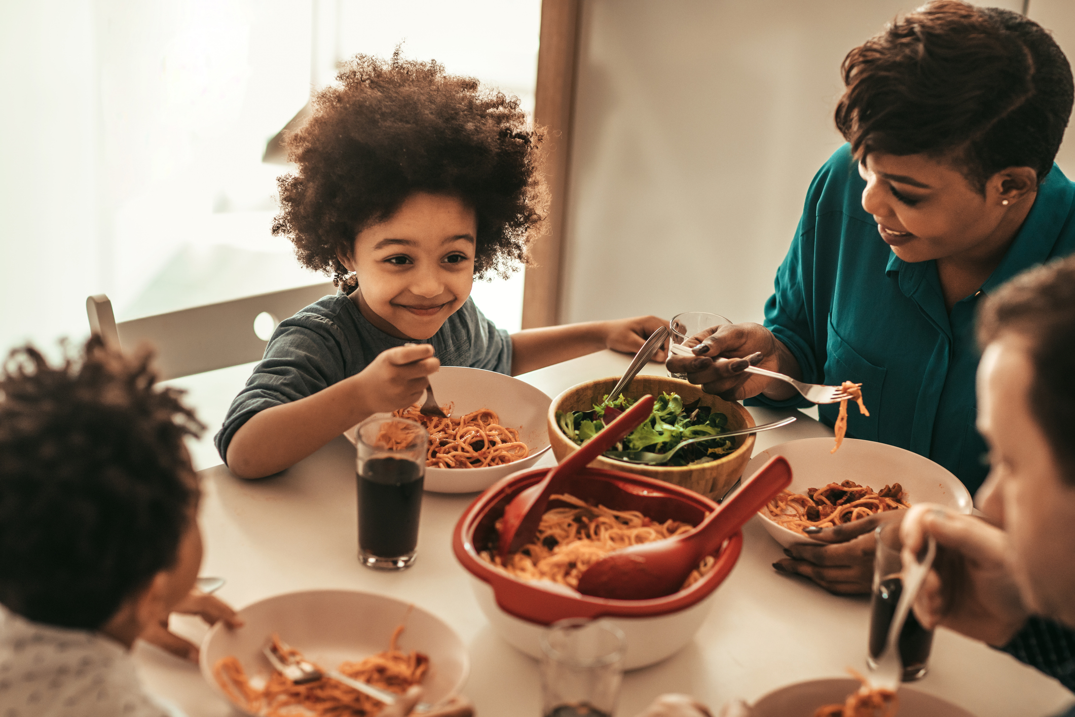 Family Having Spaghetti and Salad Dinner Together at Home