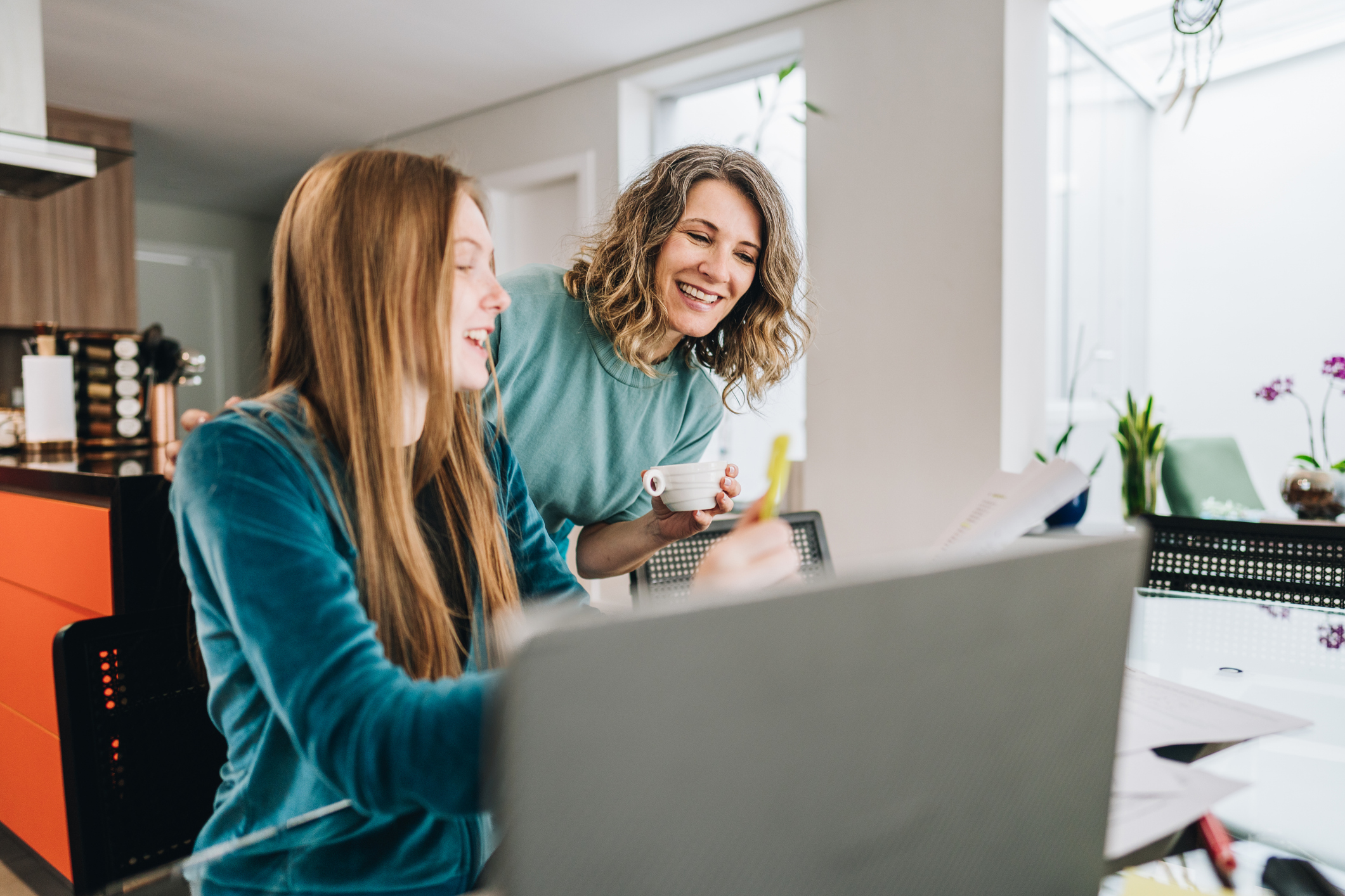 Mother Helping Her High School Student With Homework on a Laptop in the Kitchen