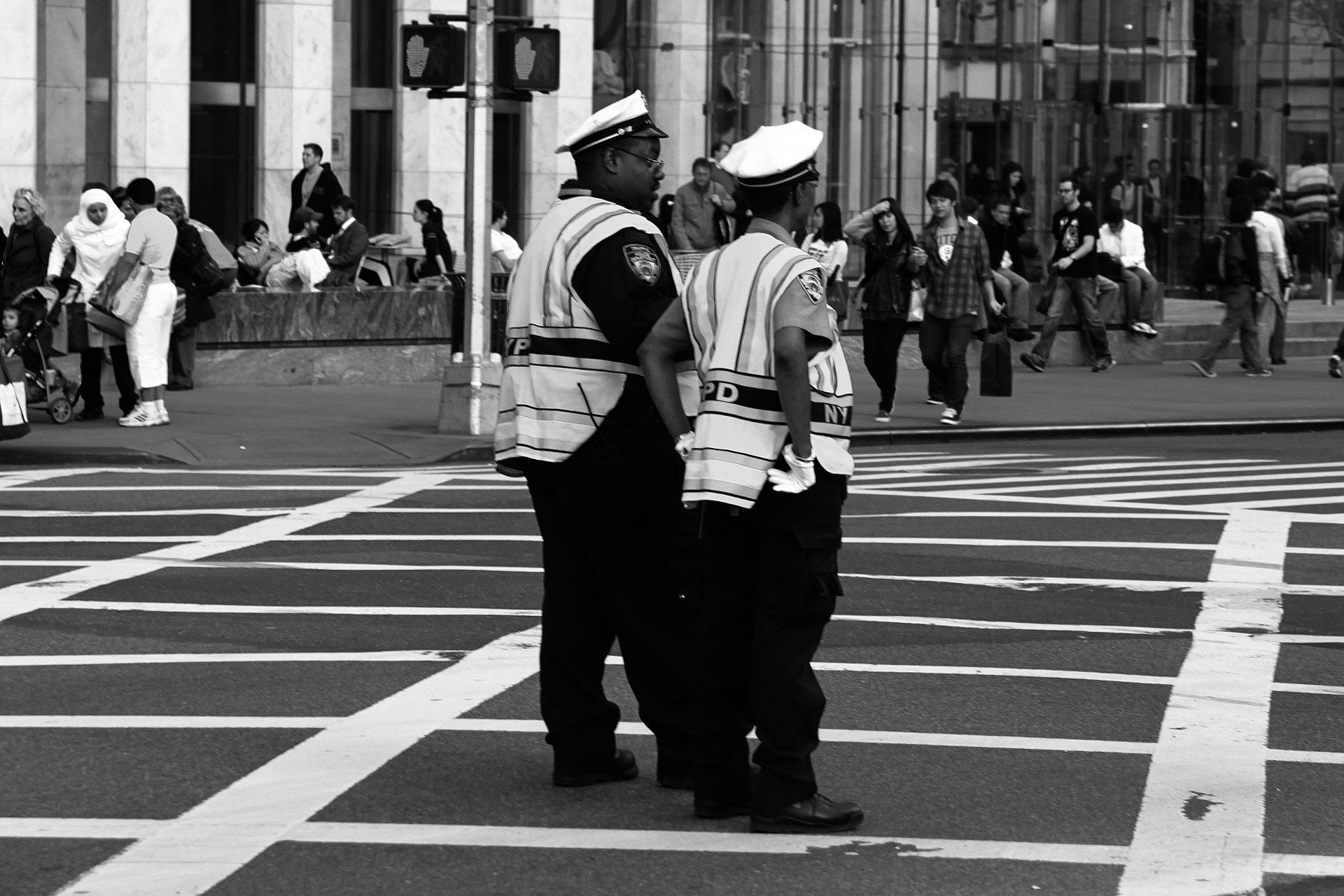 Two police officers standing in a crosswalk
