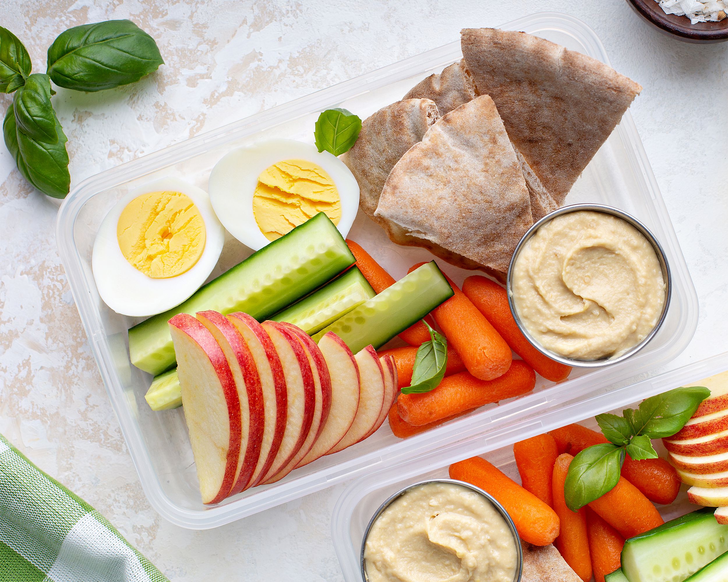 Hummus in a lunch box with veggies and pita