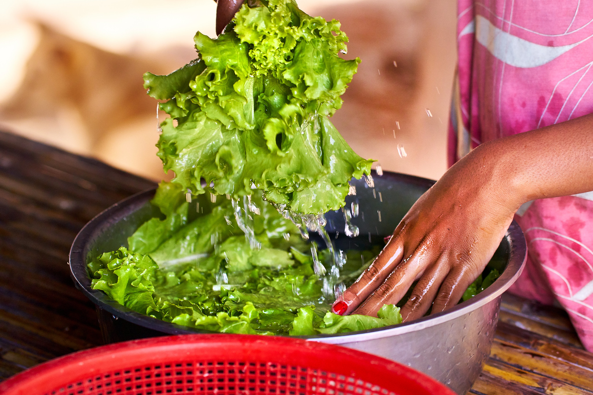 Mid-Section of a Woman Washing Lettuce in Water, Selective Focus