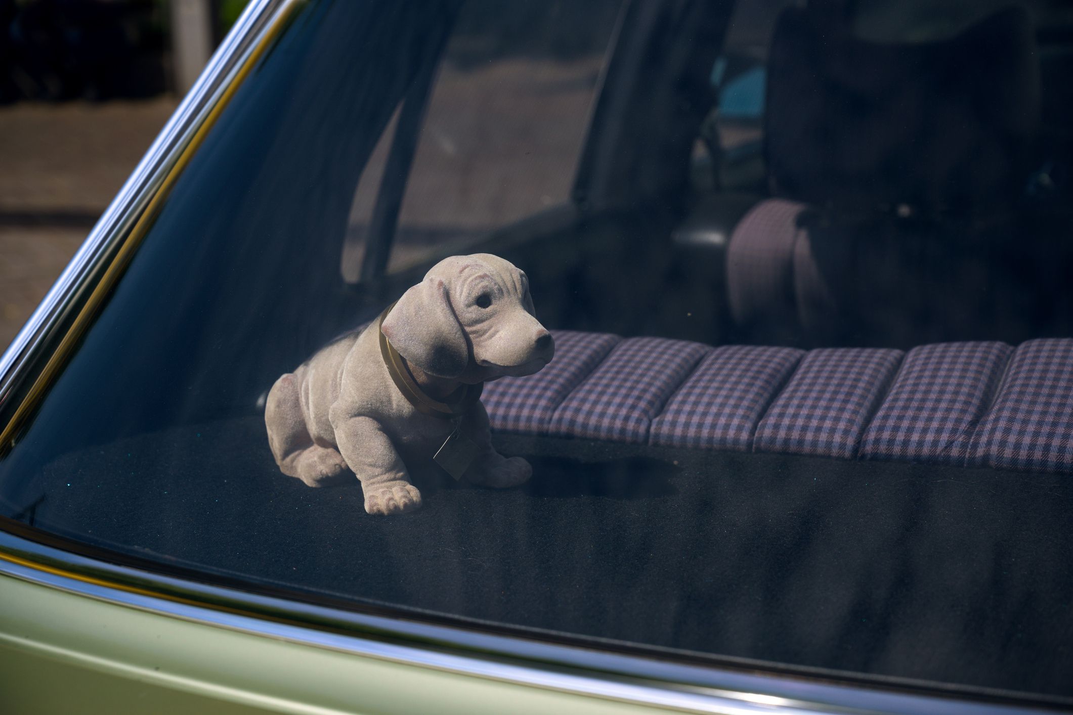 bobblehead dachshund, in german wackeldackel, on the parcel shelf in the car, a popular accessory in the 1970s, copy space, selected focus,