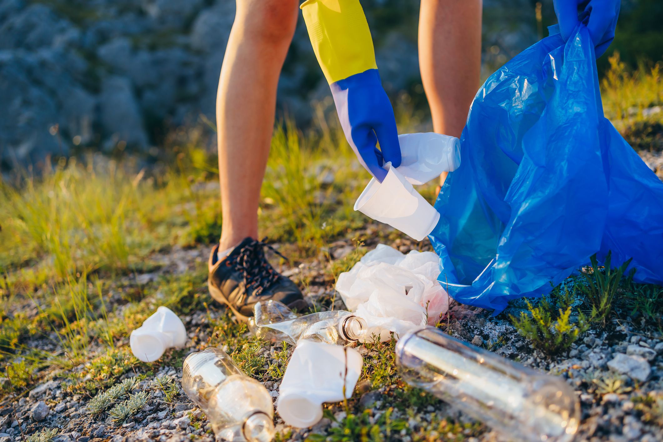 Woman activist picking up trash in nature