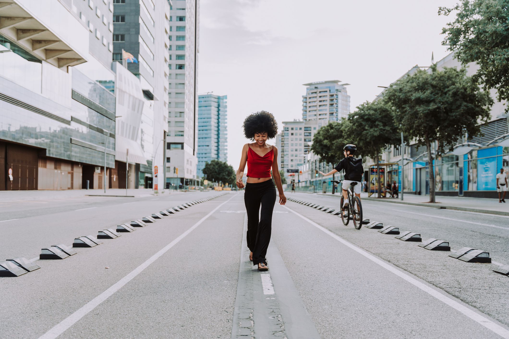 Beautiful young happy african woman with afro curly hairstyle strolling in the city - Cheerful black student walking on the streets