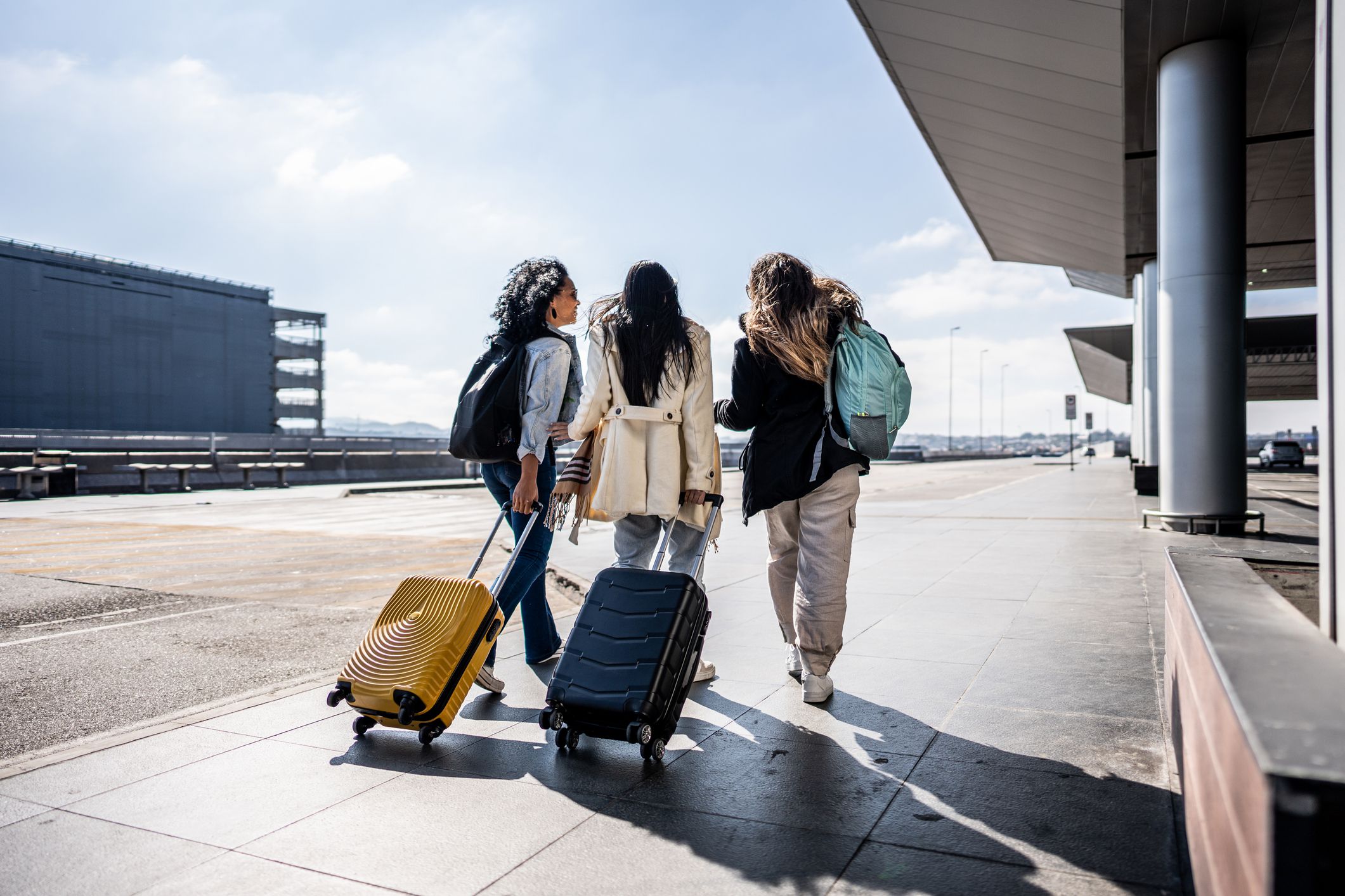 Rear view of friends walking at the airport