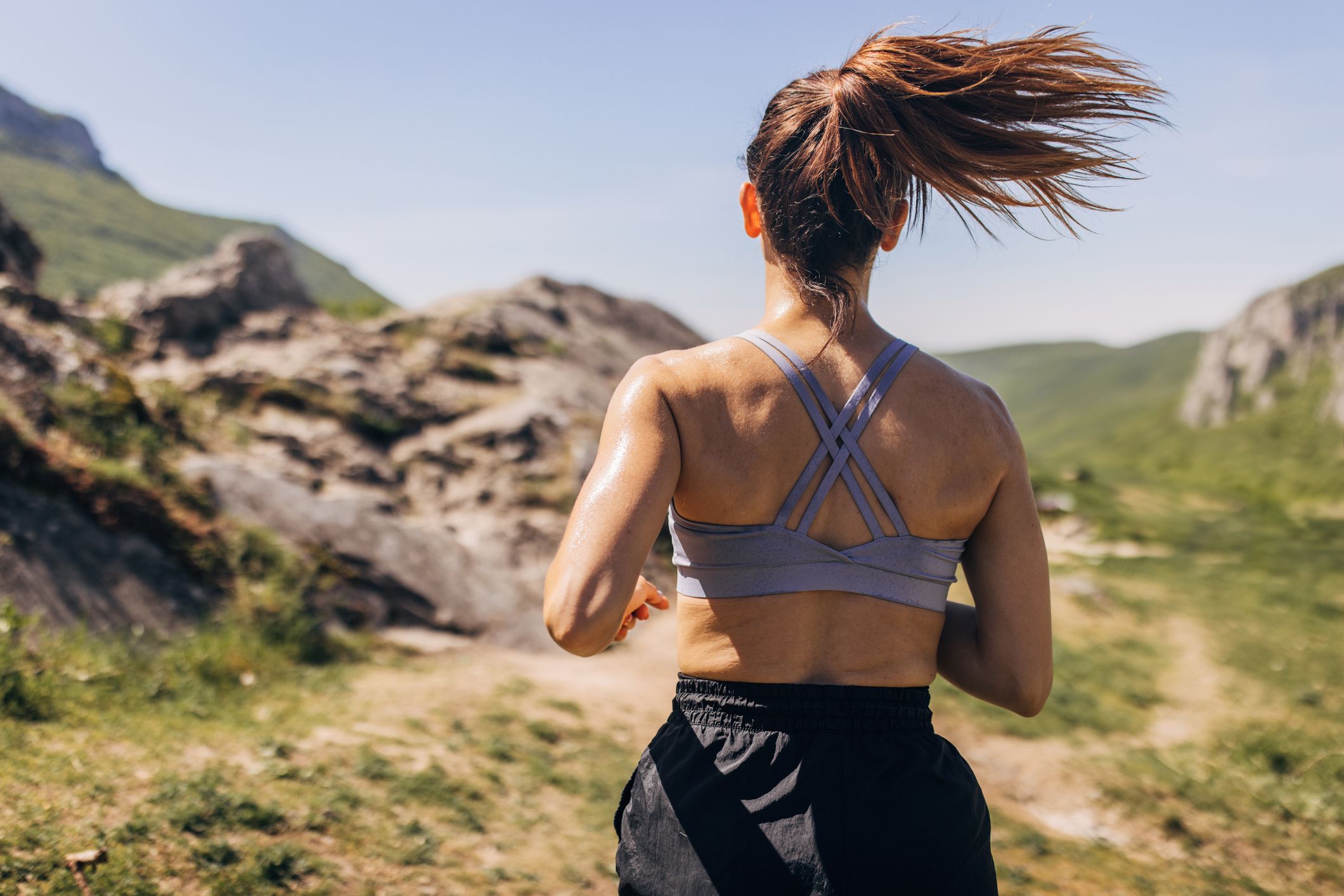 Mid adult woman running on the hill and mountain ridge