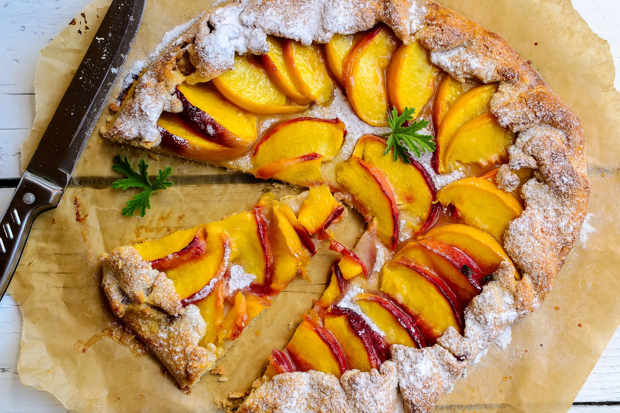 Homemade rustic peach galette on wooden table