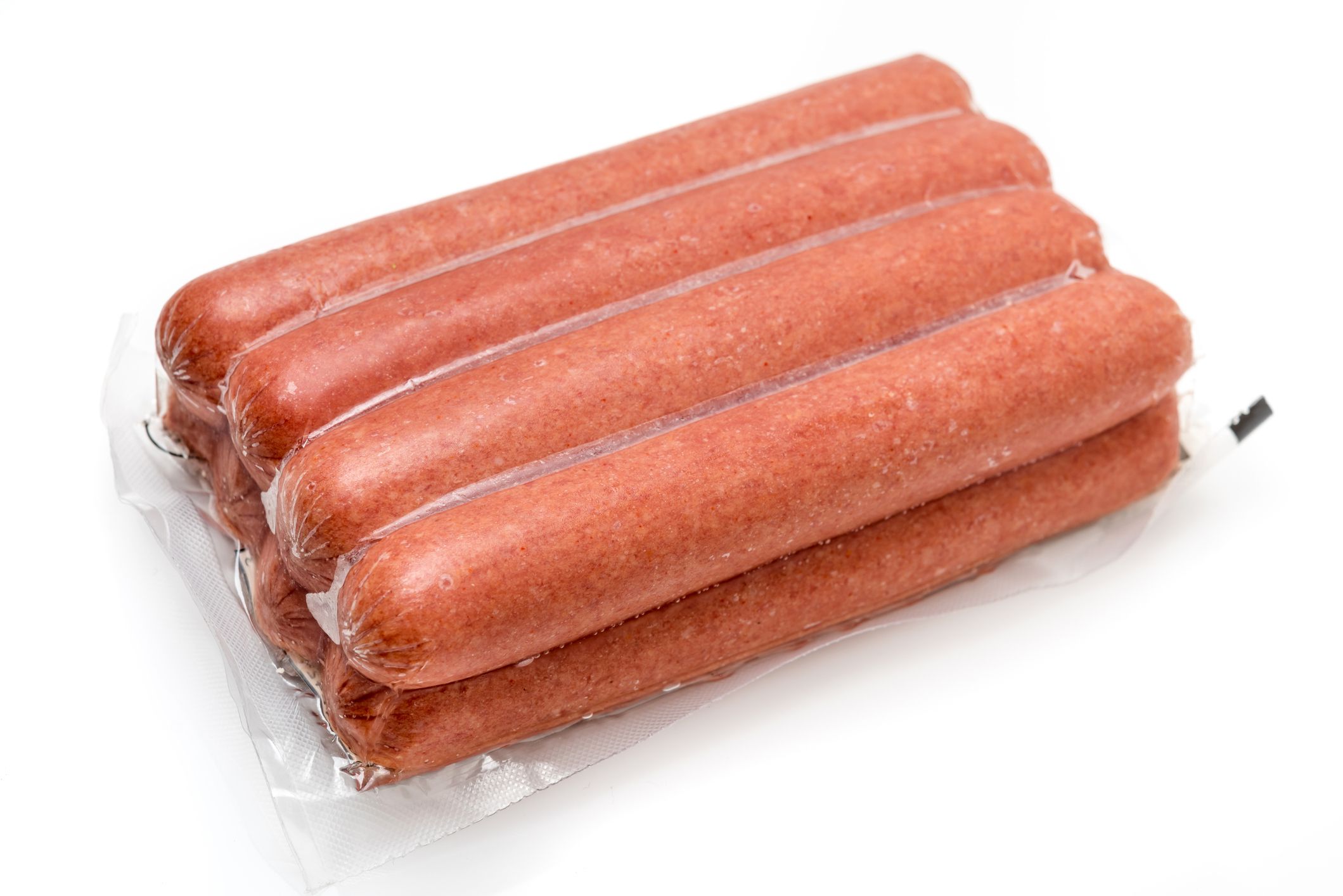 Vacuum packed package of hotdog sausages on white background