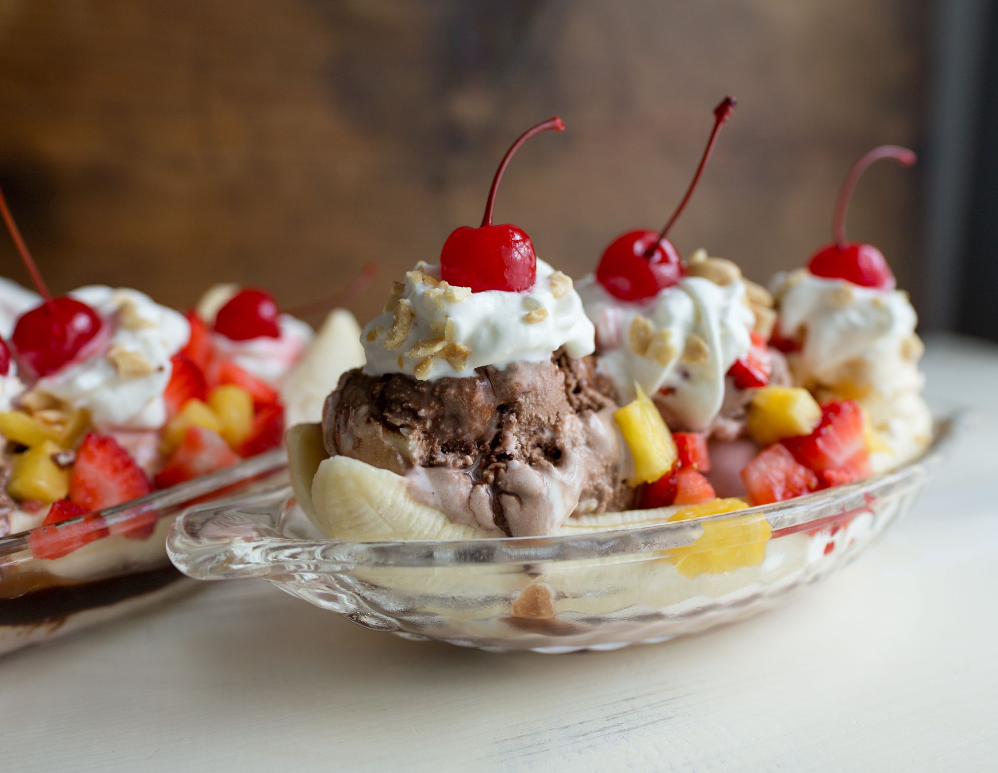 Banana splits with chocolate, vanilla and strawberry ice cream. Whipped cream topping with cherries.
