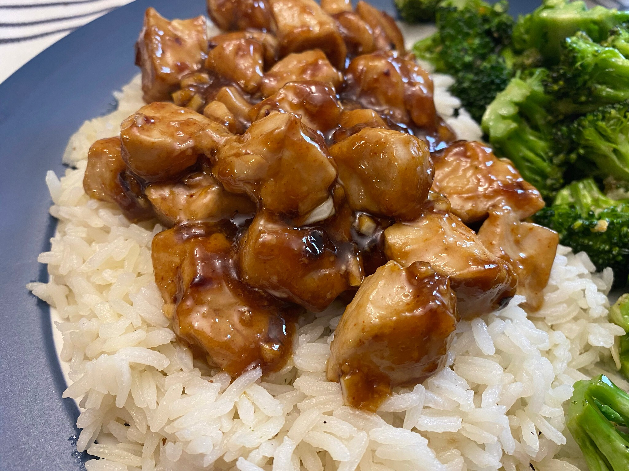 Chili Garlic Chicken and Rice With a Side of Broccoli, on a Plate