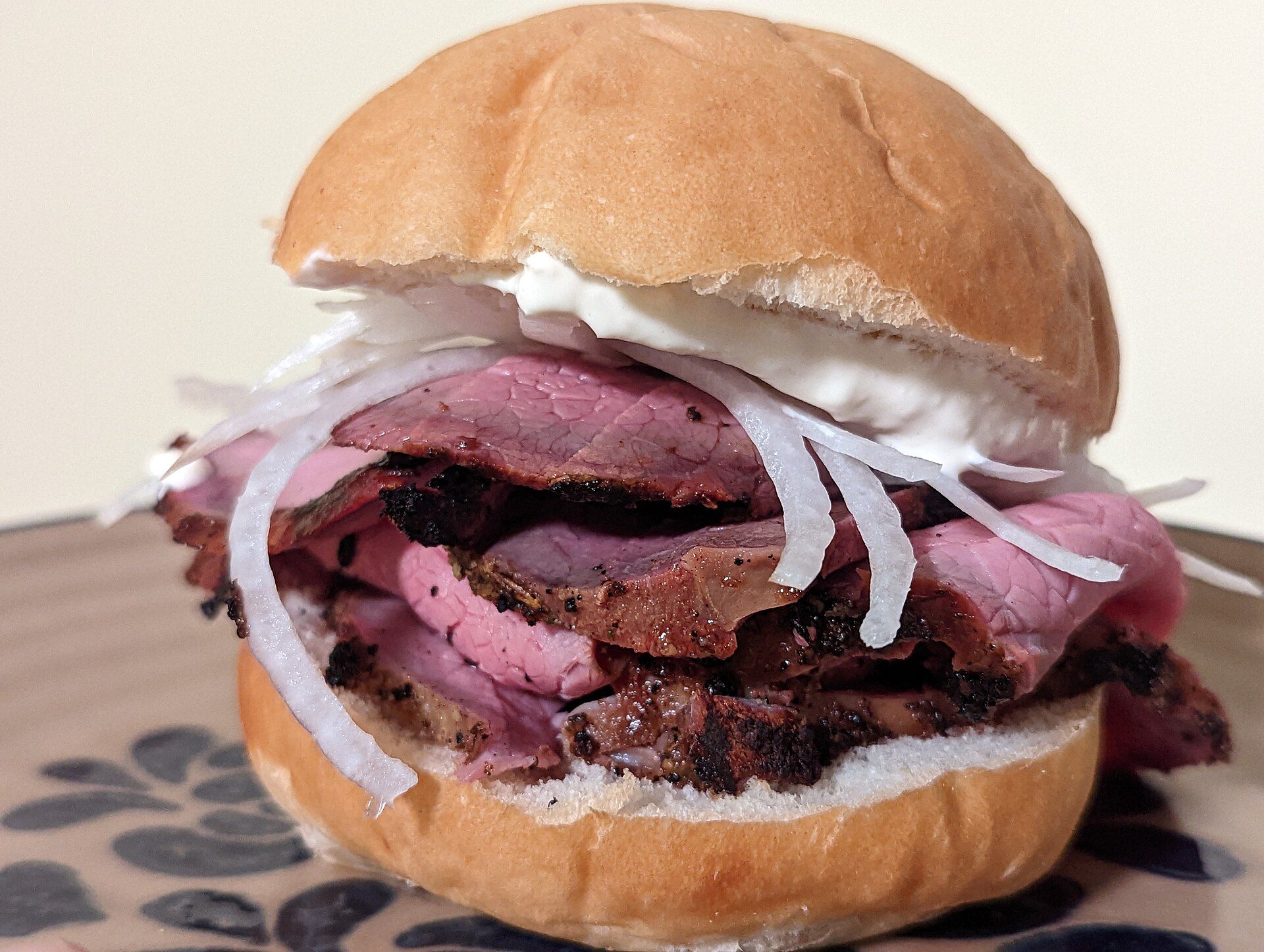 Picture of authentic pit beef sandwich with tiger sauce and onions