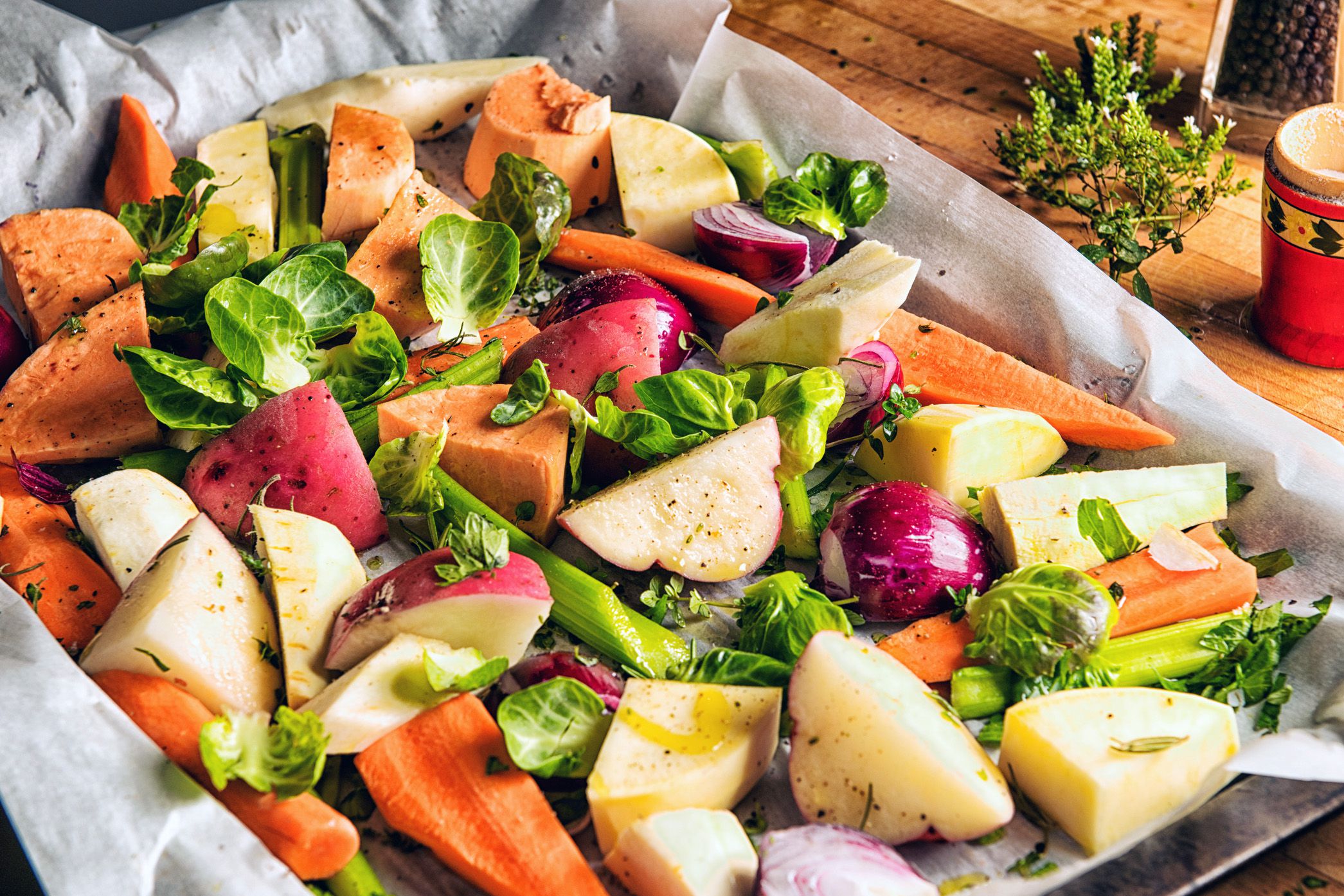 Roasted root vegetable medley on parchment paper on a steel baking tray