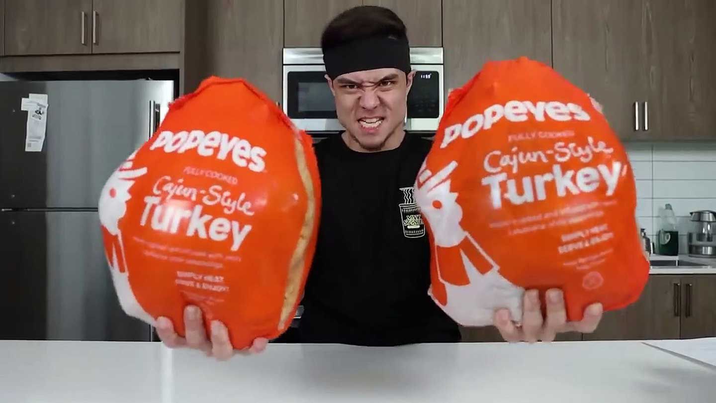 Man holding two Popeyes Cajun-style Turkeys