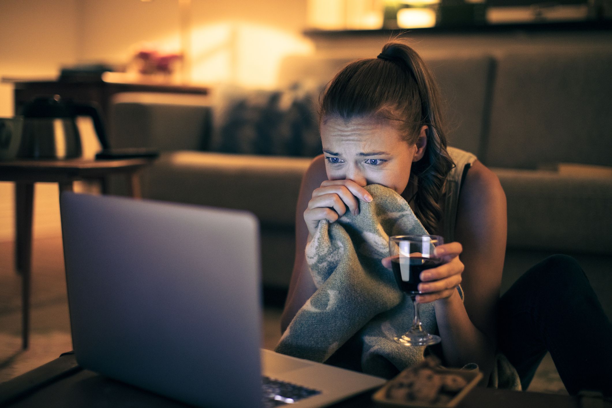 Close up of a woman watching a movie at night