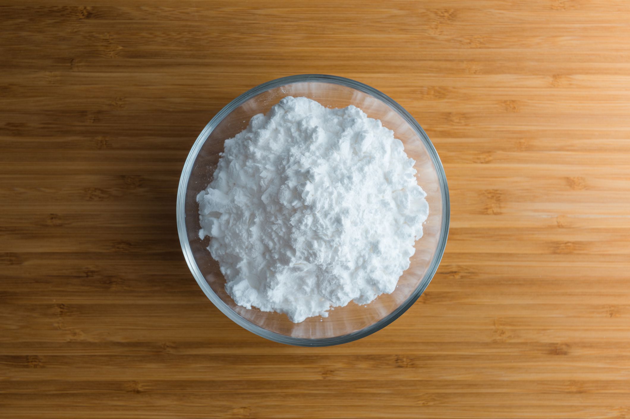 cornstarch in glass bowl on wooden surface