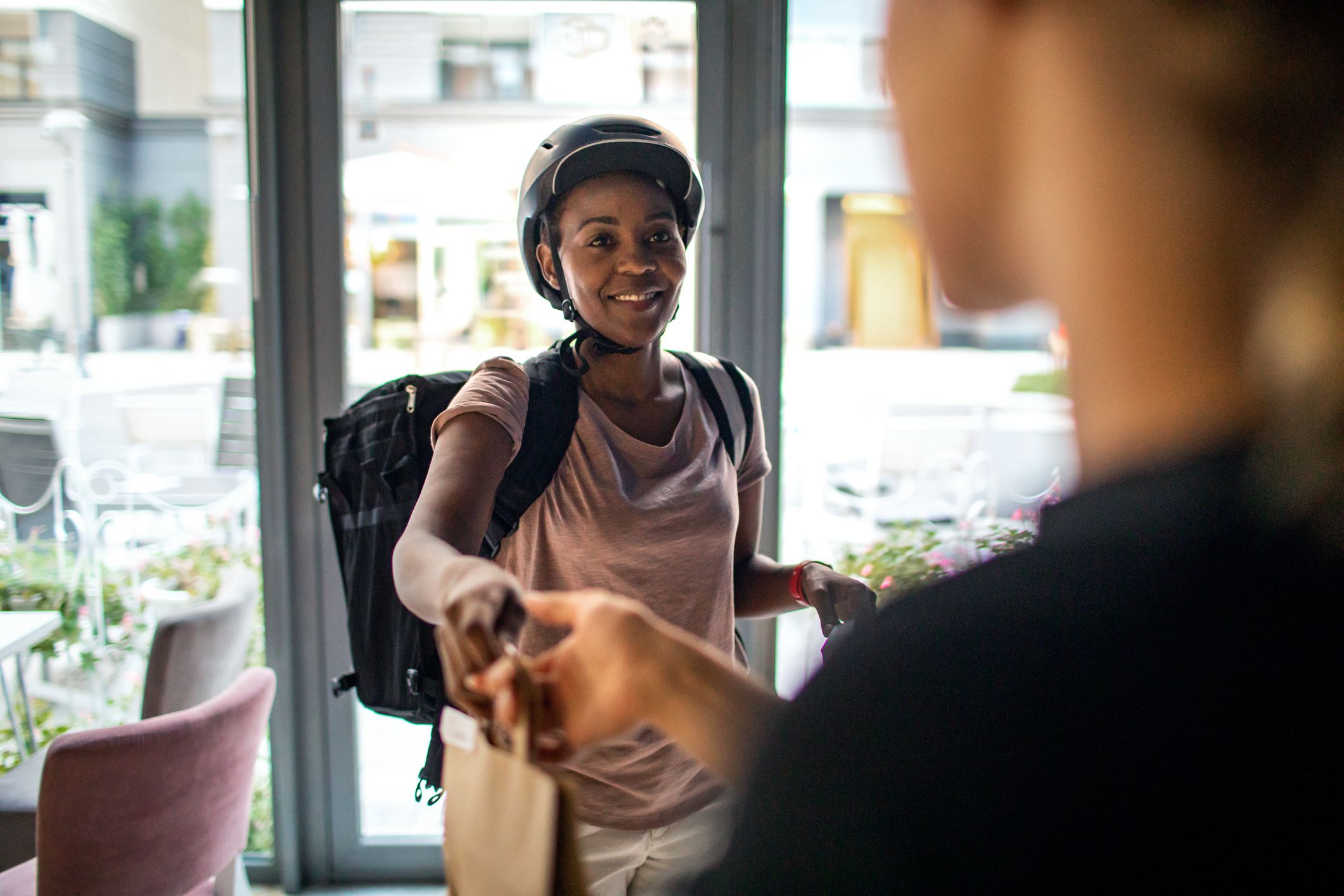 African delivery woman delivering package to customer.
